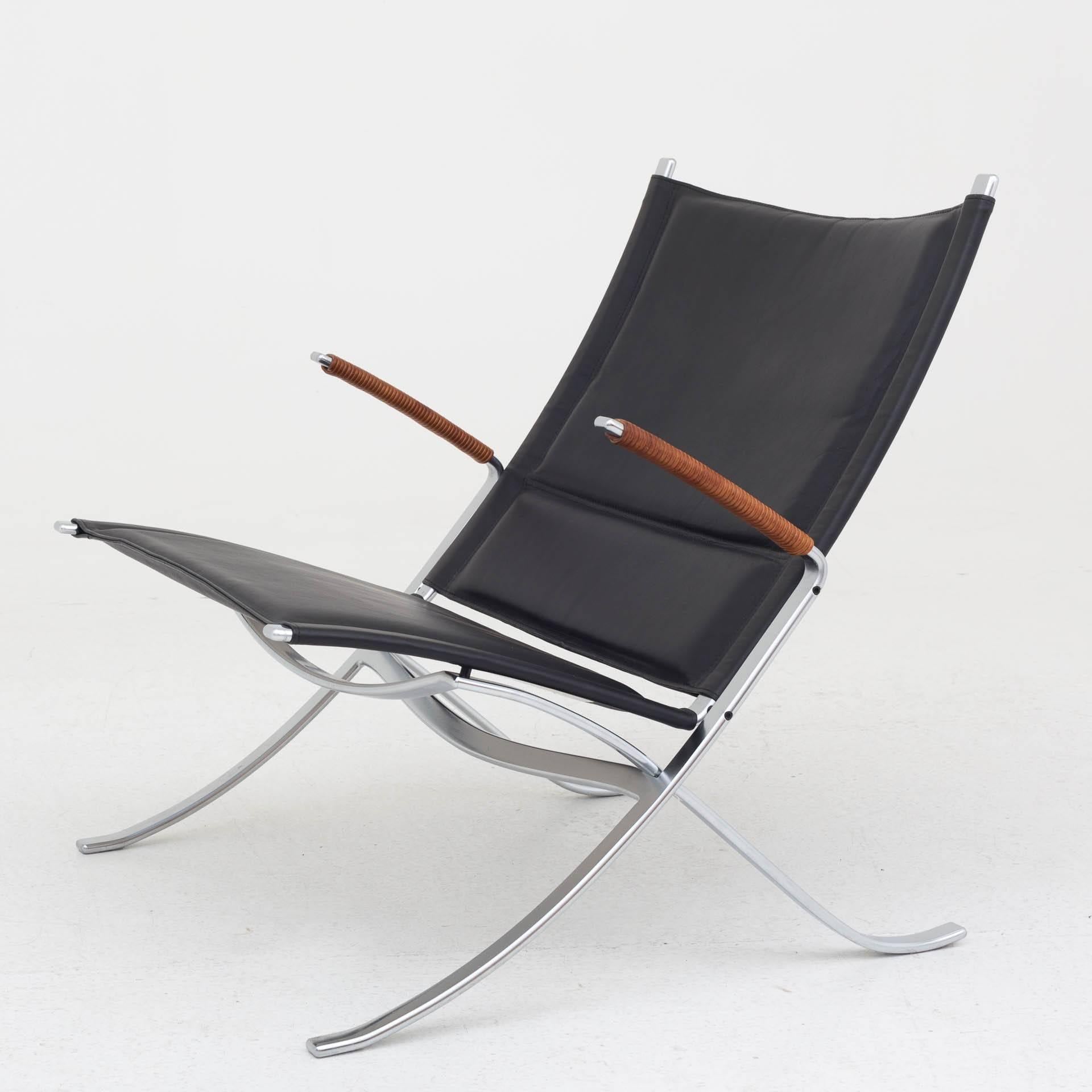 FK 82 – X-chair in black leather and natural leather on armrests. Steel frame.