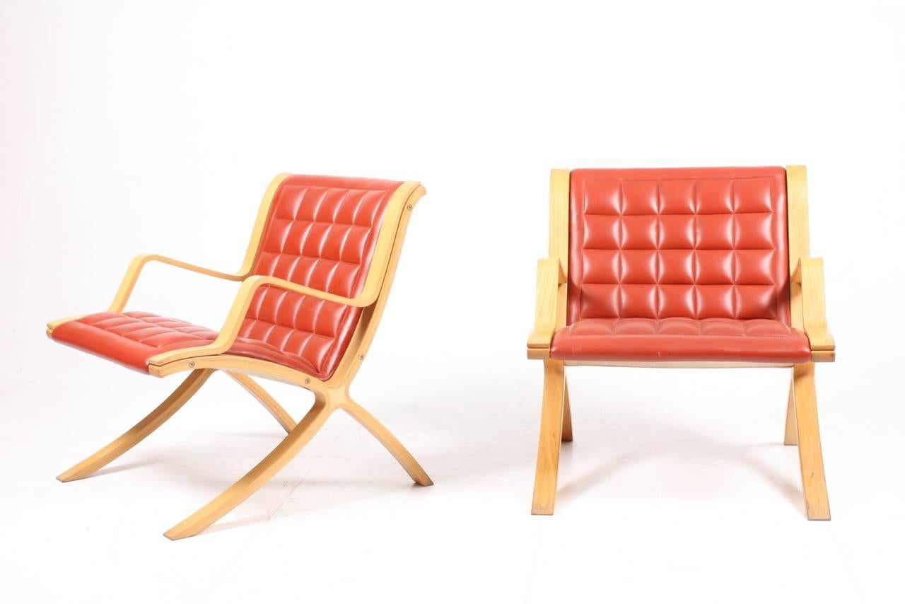 Pair of great looking X lounge chairs in beech and leather. Designed by Peter Hvidt and Orla Mølgaard for Fritz Hansen. Made in Denmark. Great original condition.