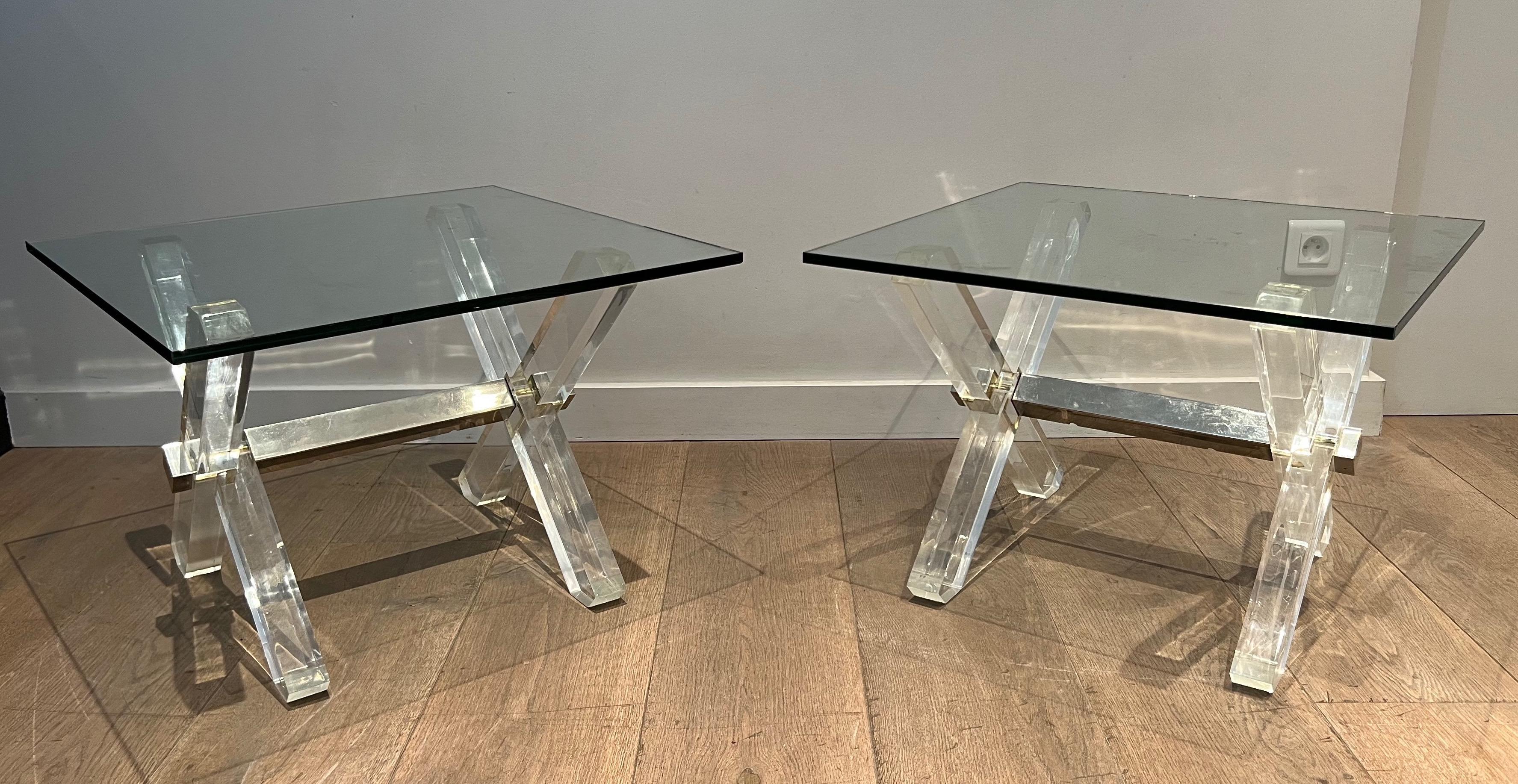 This nice and rare pair of side tables are made up of an X-shaped base in plexiglass and chrome topped with a thick slab of glass. This is a French work. Circa 1970