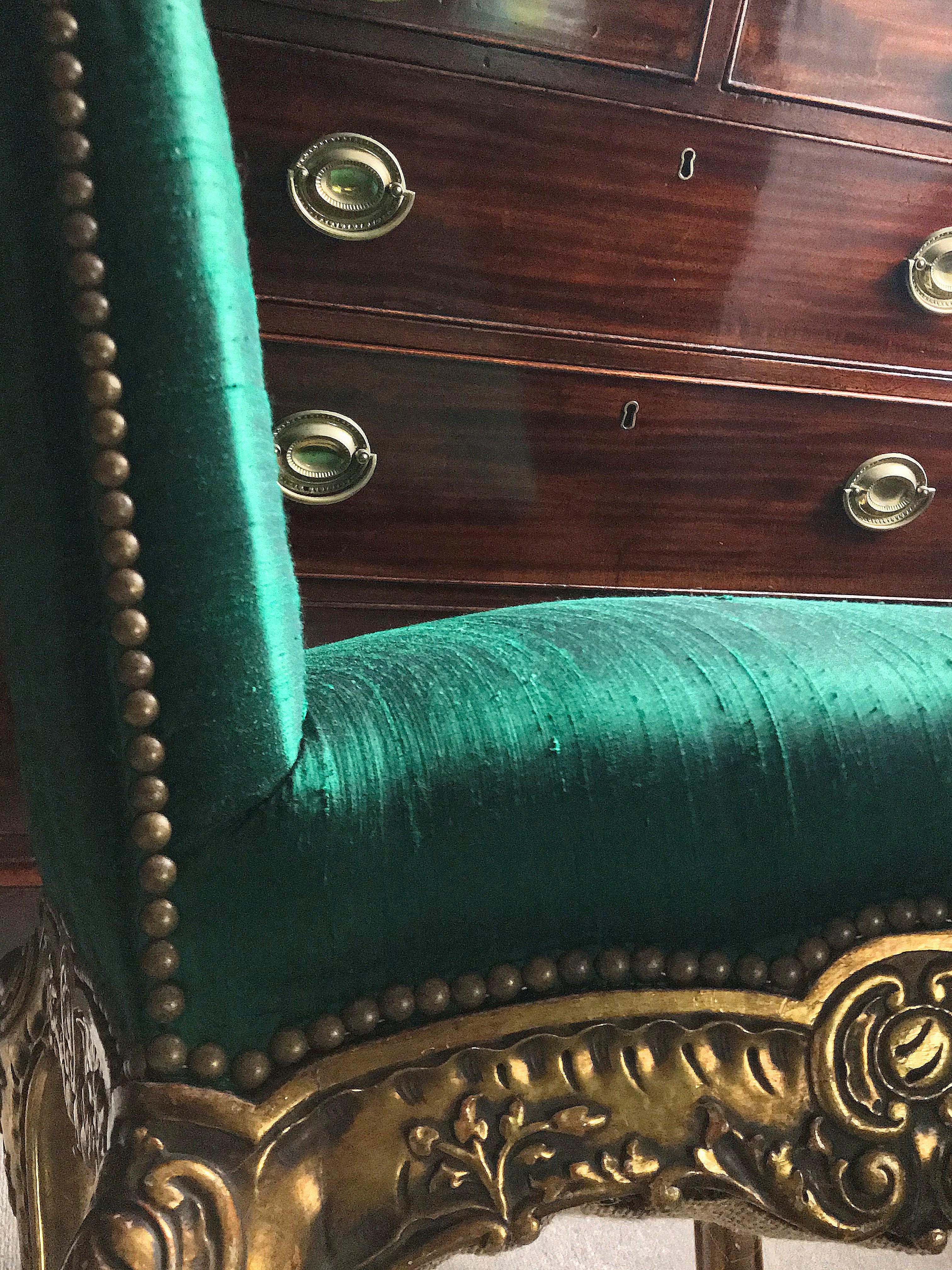 A pair of Spanish carved giltwood side chairs with cabriole legs and newly upholstered in emerald silk with gold studding.
  