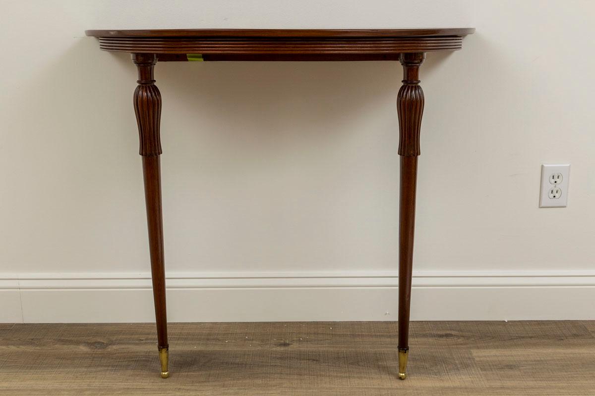 A beautiful pair of modernized Italian Neoclassical style wall mounted demilune-shaped console tables in a lovely dark shellaced teak wood on elegant fluted and reeded legs finishing on high brass sabots

Origin: Italy

Dating: 1940ca

Dimensions: