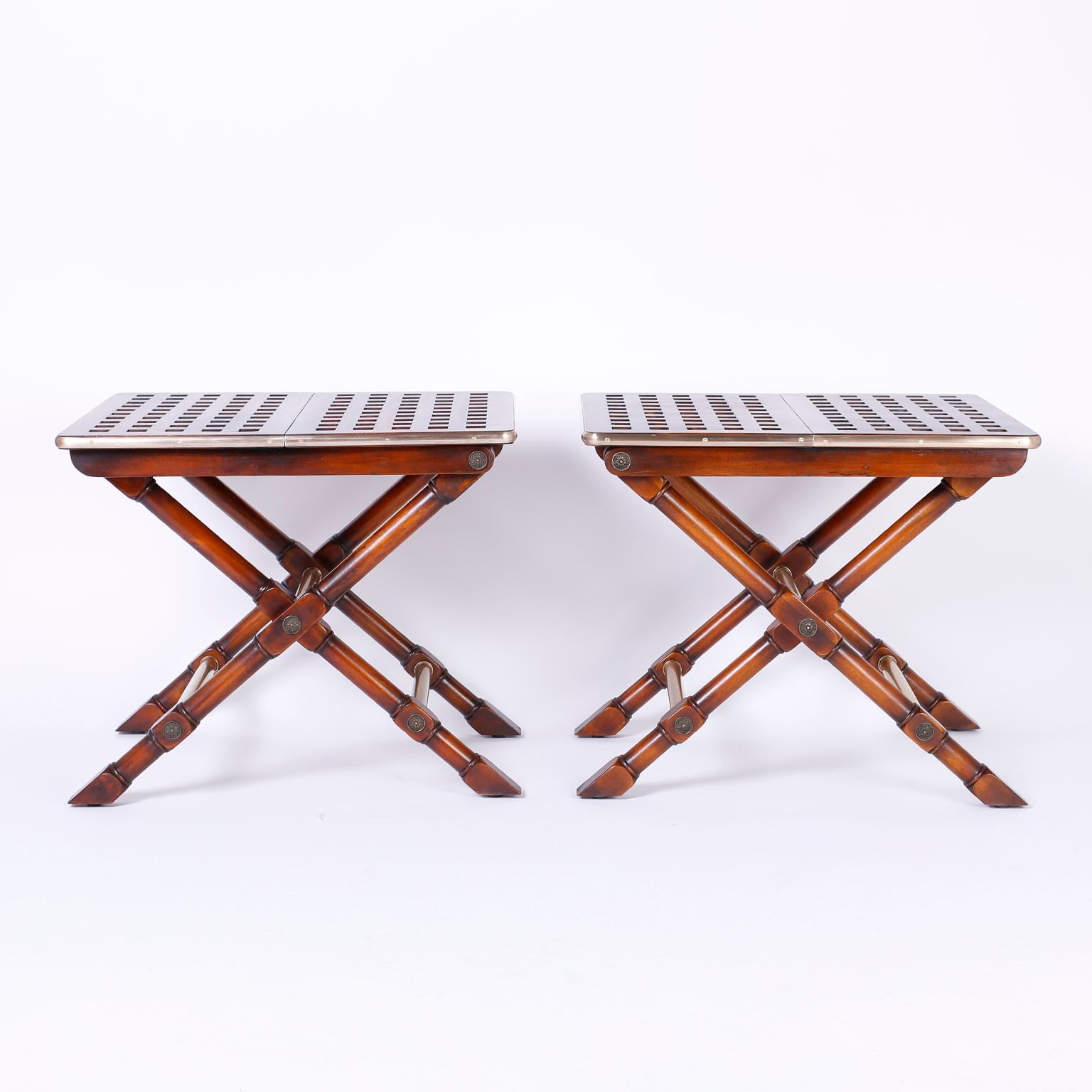 Unusual and fine pair of mahogany tables featuring criss cross construction on top banded with thick brass, X style turned legs and tubular brass stretchers. All the brass has been hand polished and lacquered for easy care, these tables conveniently
