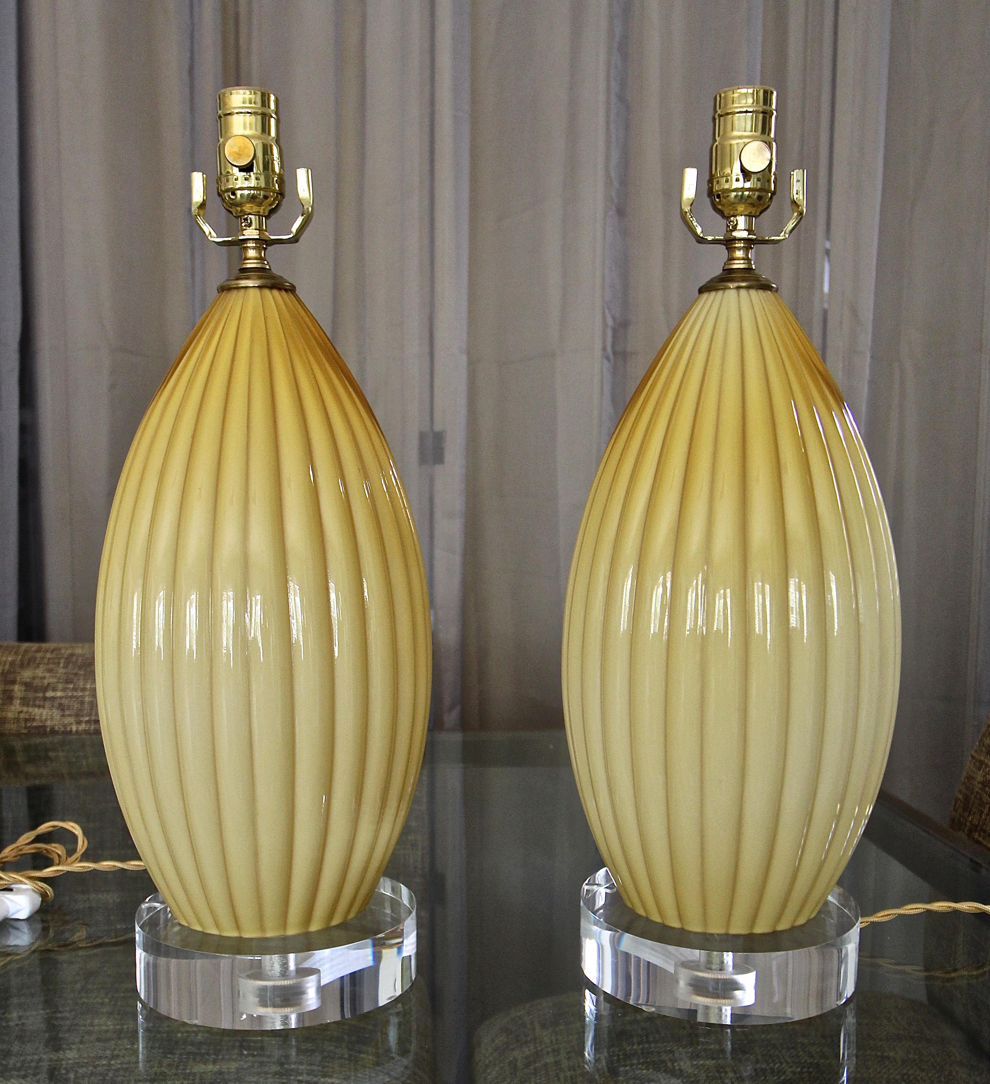 Pair of Murano Italian cased glass ribbed lamps, in a yellow butterscotch color on new custom acrylic bases. Newly wired for US with French style twisted rayon covered cords, lacquered brass fittings and on/off sockets. Shade for photography only