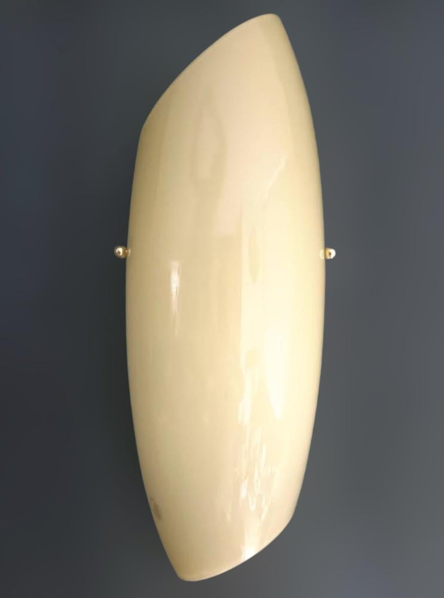 Italian wall light with creamy yellow Murano glass shade in the shape of shell, mounted on white metal frame / Made in Italy in the style of Vistosi, circa 1960s
Measures: Height 18 inches, width 7 inches, depth 2.5 inches
1 light / E26 or E27 type