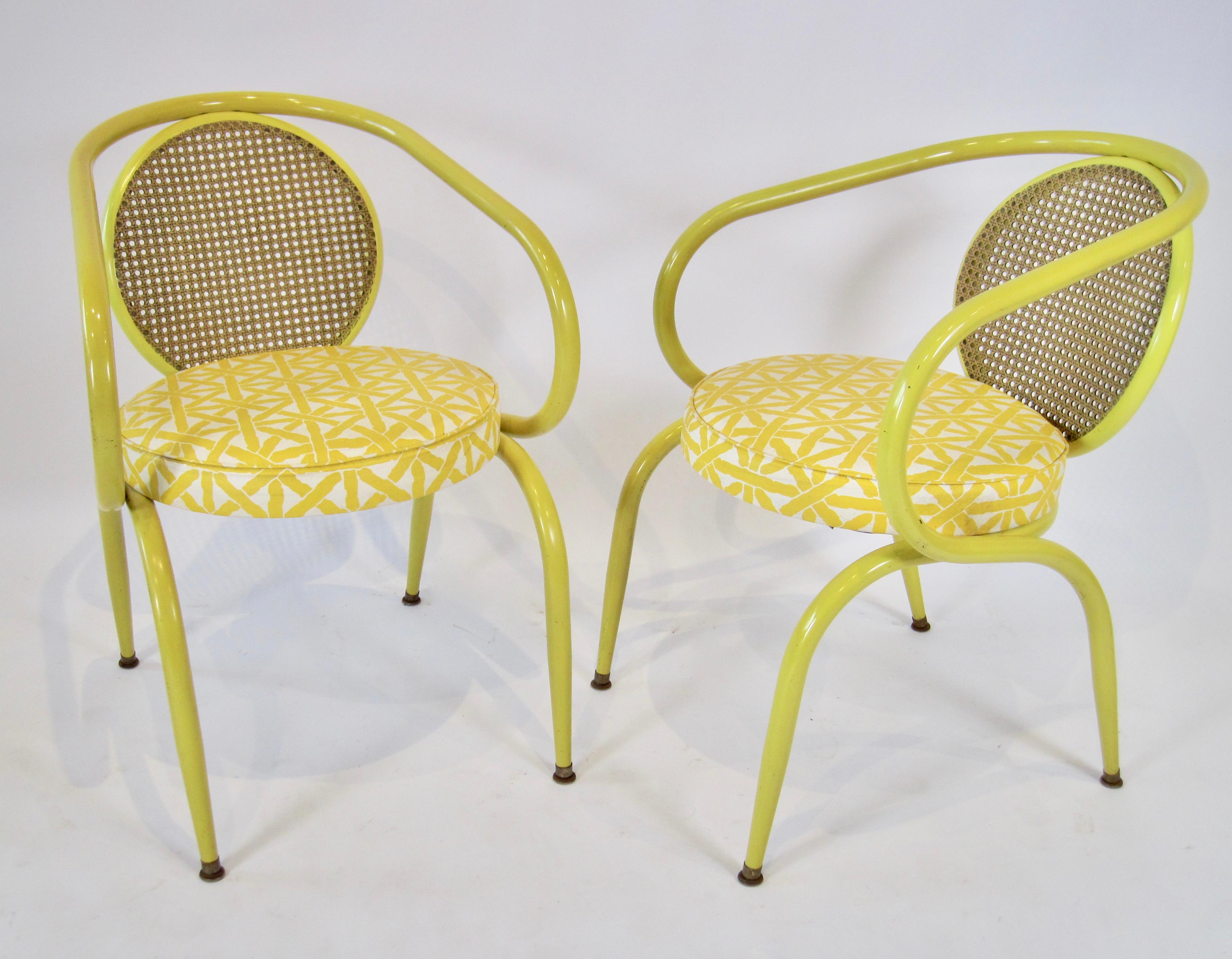 Rare pair of Howell decorator chairs with tubular steel frame, round graphic vinyl covered cushioned seat, and pressed fiberglass cane style back. 

Beginning as a foundry in 1867, the Howell Company produced fluting and sad irons in its Geneva,