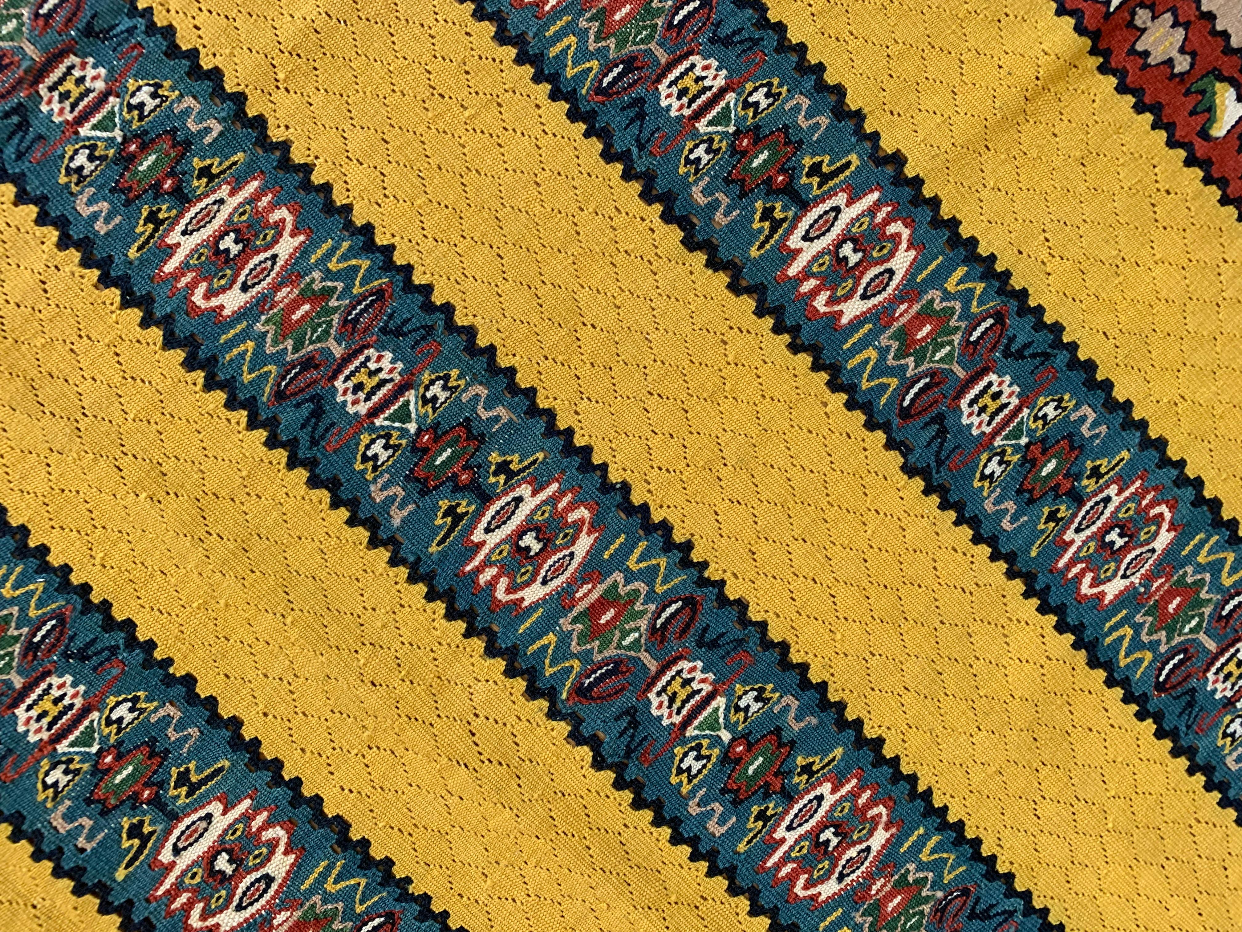 Estos atrevidos kilims amarillos son nuevas alfombras de lana y seda tejidas a mano, fabricadas a principios del siglo XXI. El diseño presenta un fondo amarillo con cuatro paneles de rayas decorativas tejidas con intrincados motivos geométricos. A