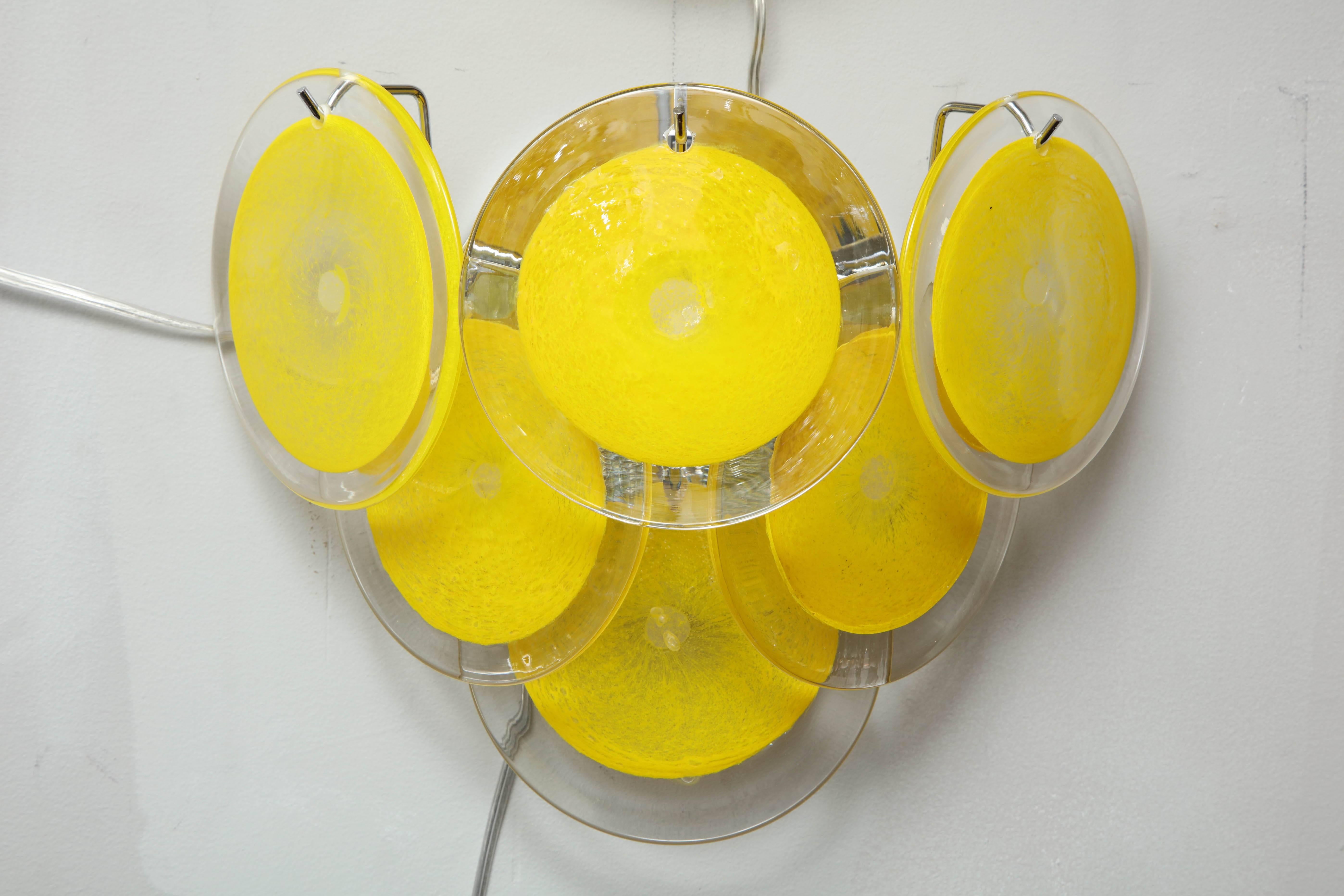 Pair of yellow Murano glass disc sconces. New frames with vintage glass.