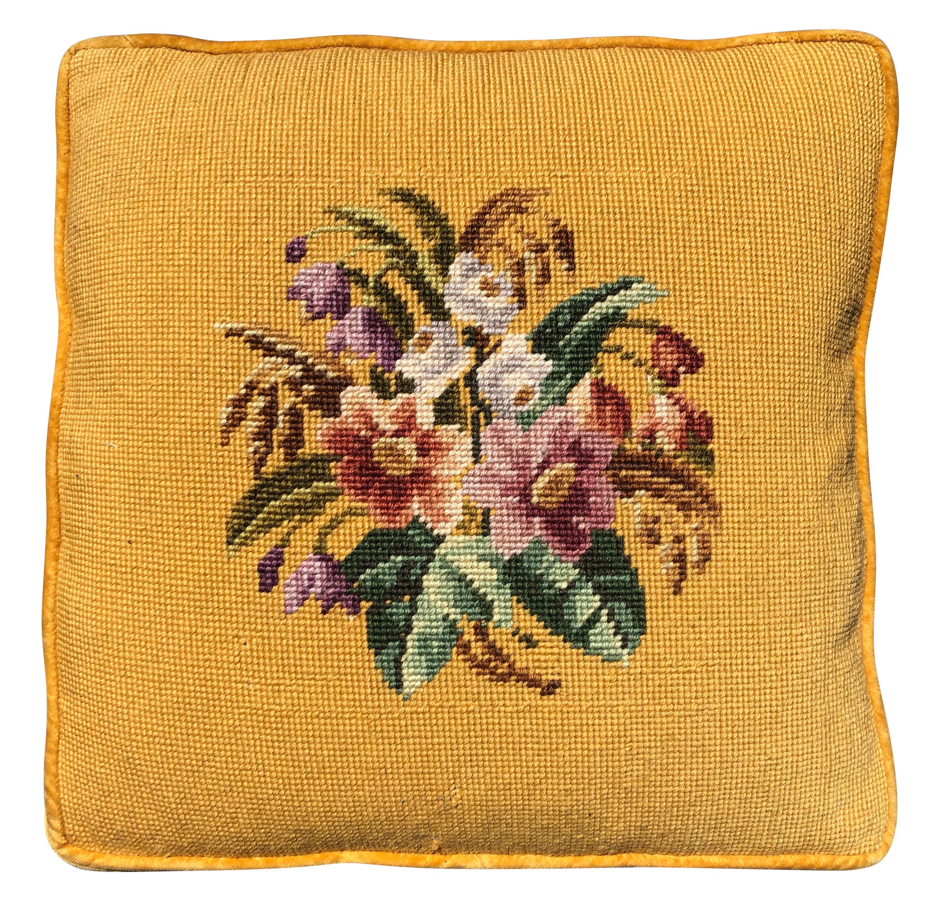 These are a pair of charming yellow needlepoint embroidered pillows. The back is covered in the same gold colored velvet while the front has yellow/gold piping. Each pillow has its own floral motif, but have the same yellow background and look great