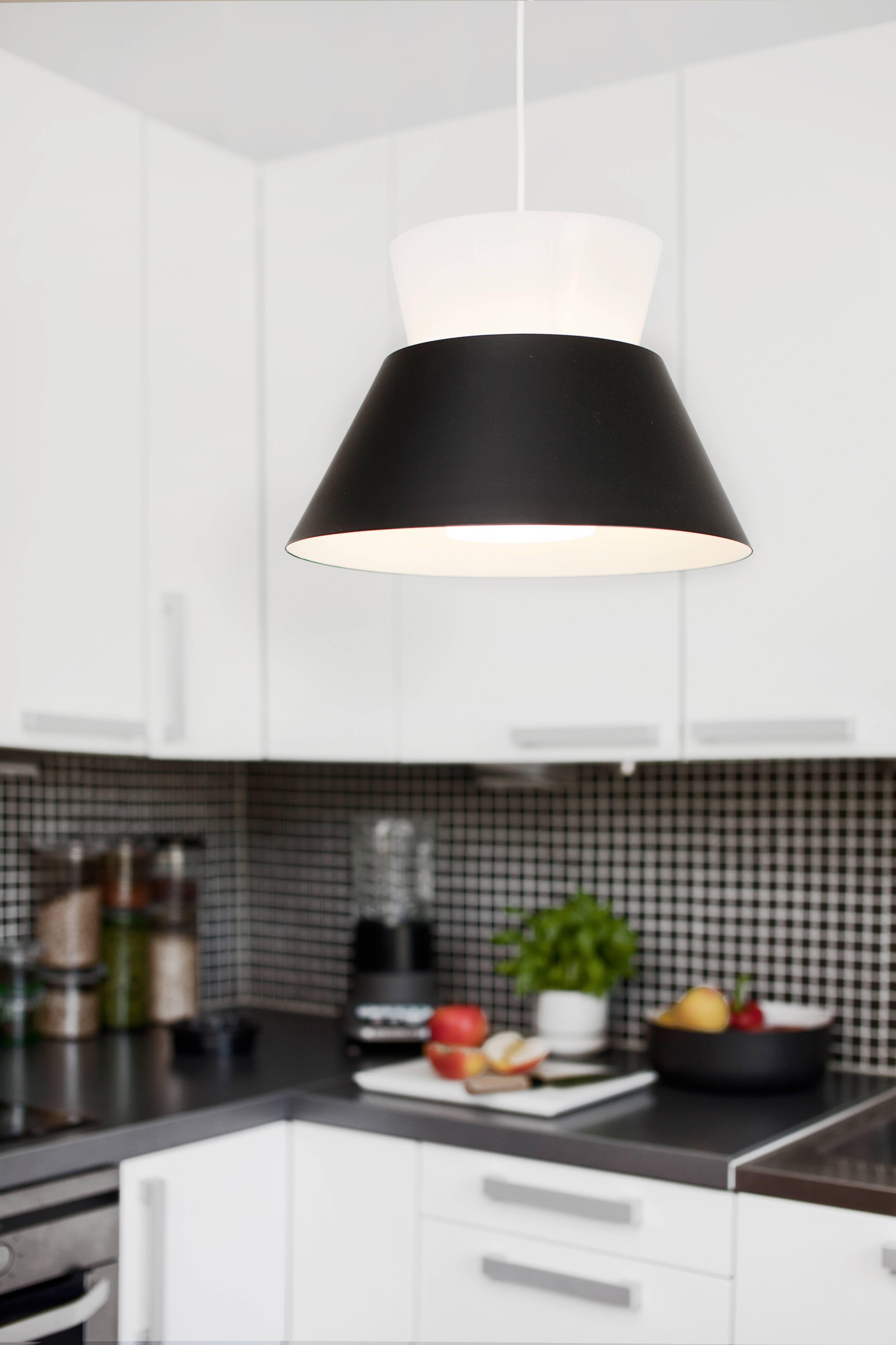Pair of Yki Nummi '1955' Pendants for Innolux Oy in Black and White. Designed in 1955, Nummi's innovative design is formed by two cone-shaped shades, the top is of white acrylic and the bottom pressure turned painted aluminum. As Nummi once astutely