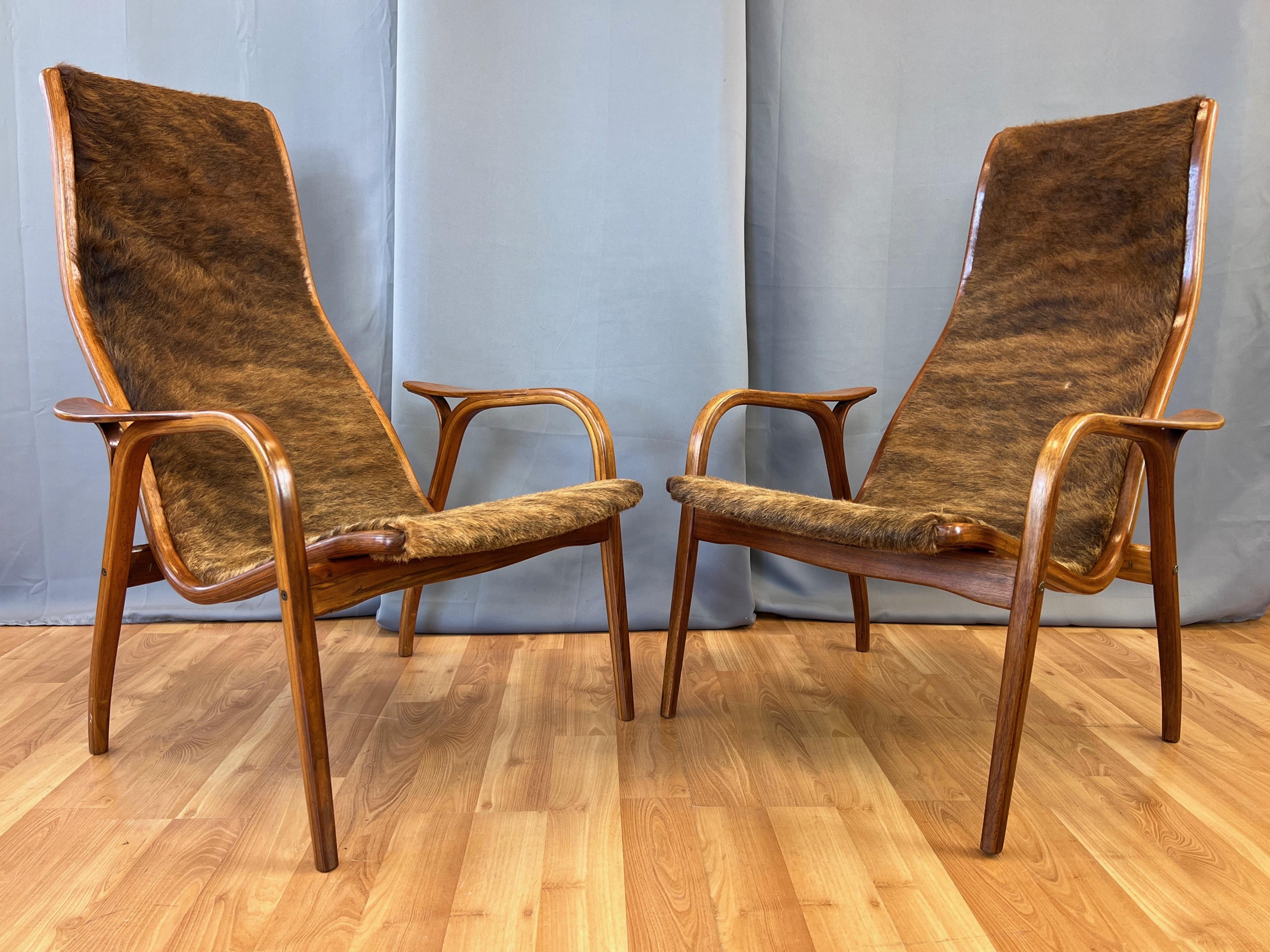 A pair of fantastic 1950s Yngve Ekström teak Lamino lounge chairs with cowhide upholstery for Swedese.

Striking handcrafted bentwood teak frames with a sinuous and sleek profile that commands attention. Recently reupholstered in vintage brindle