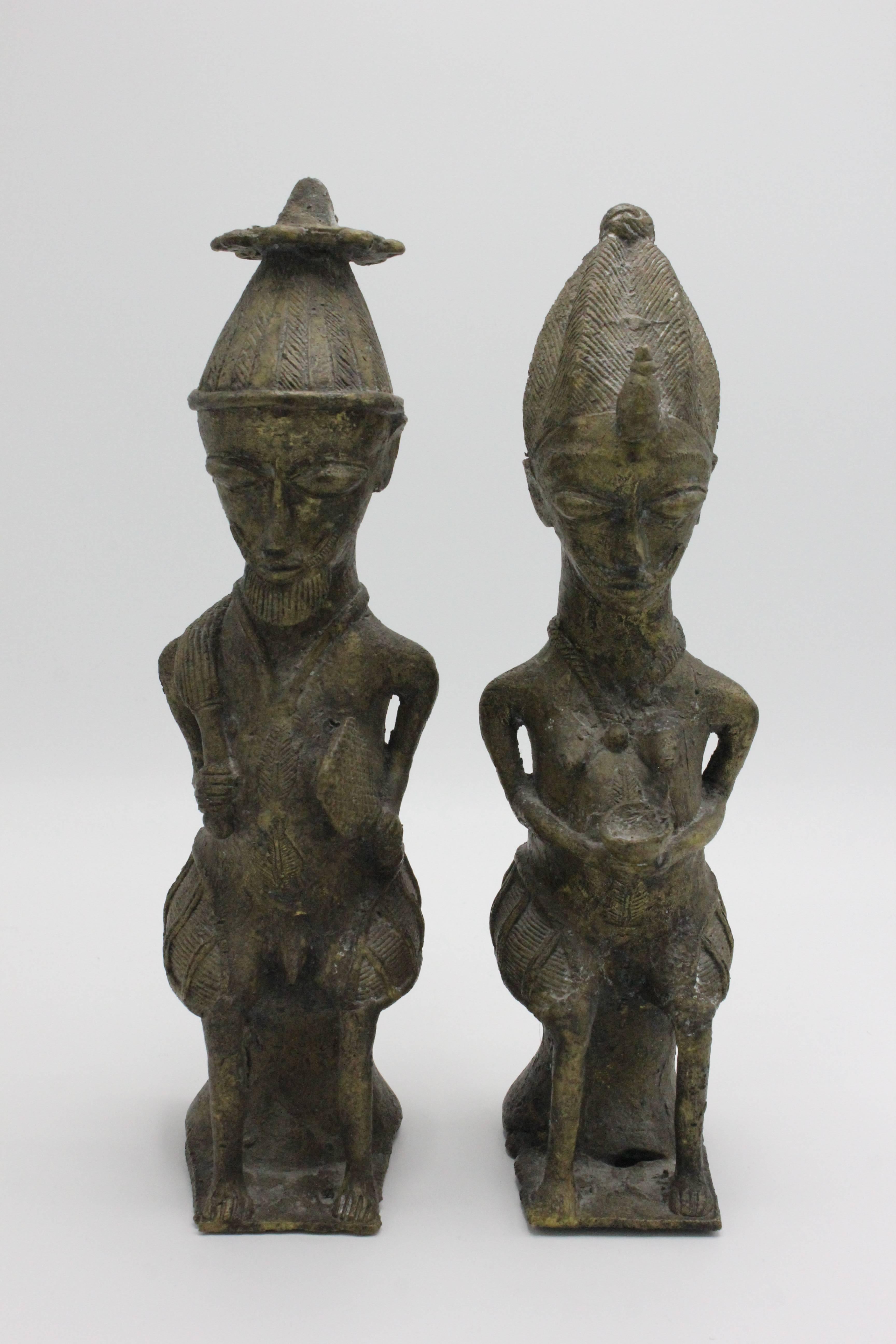 Pair of Yoruba cast brass figures for the Ogboni cult, Nigeria. The male and female pair are holding ritual pieces and are a recurring symbol of Ogboni culture. The figures symbolize the founding couple and guardians of ancient Ogboni laws.