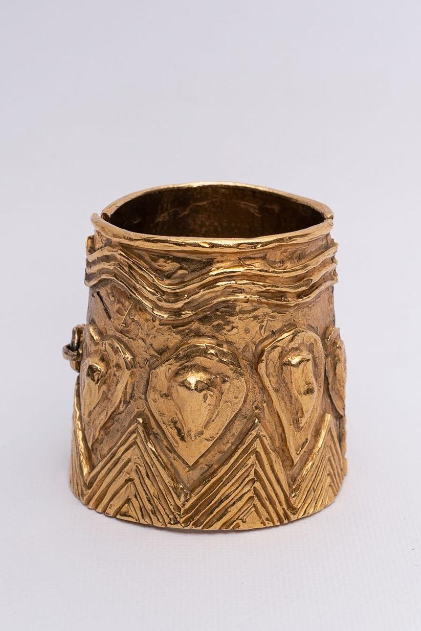Yves Saint Laurent - Pair of cuff bracelets made of hammered and engraved gilted metal.

Additional information:
Dimensions: Circumference: 14 cm (5.52 in) 
Height: 7 cm (2.76 in) 
Opening: 4.5 cm (1.77 in)
Condition: Very good condition
Seller Ref