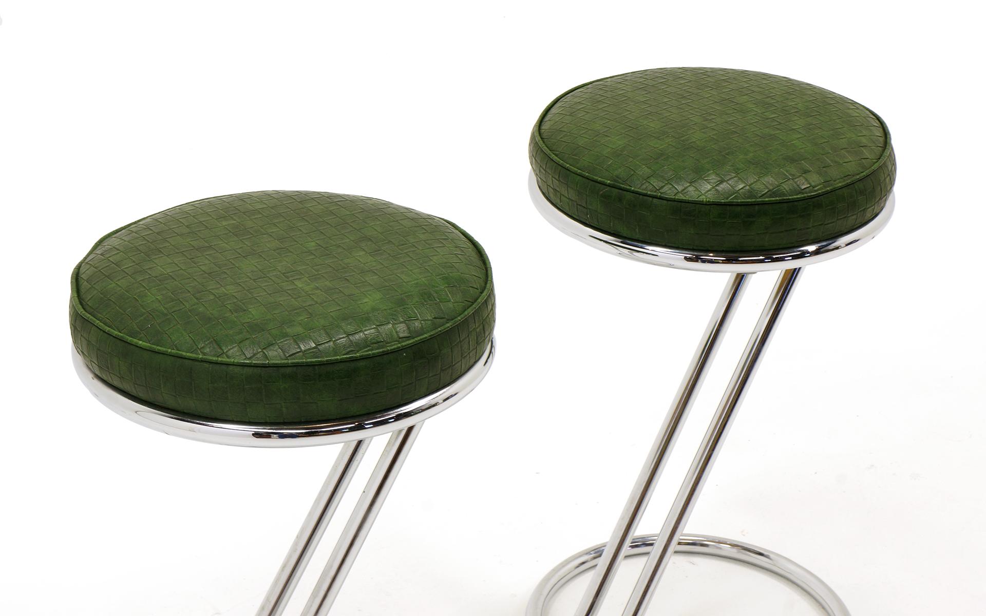 Pair of counter height bar stools designed by Gilbert Rohde for Troy Sunshade Co. Chrome frames with green faux alligator seats. Scuffs and some scratches to the chrome from use, but no pitting at all and the seats are perfect. Signed on the inside