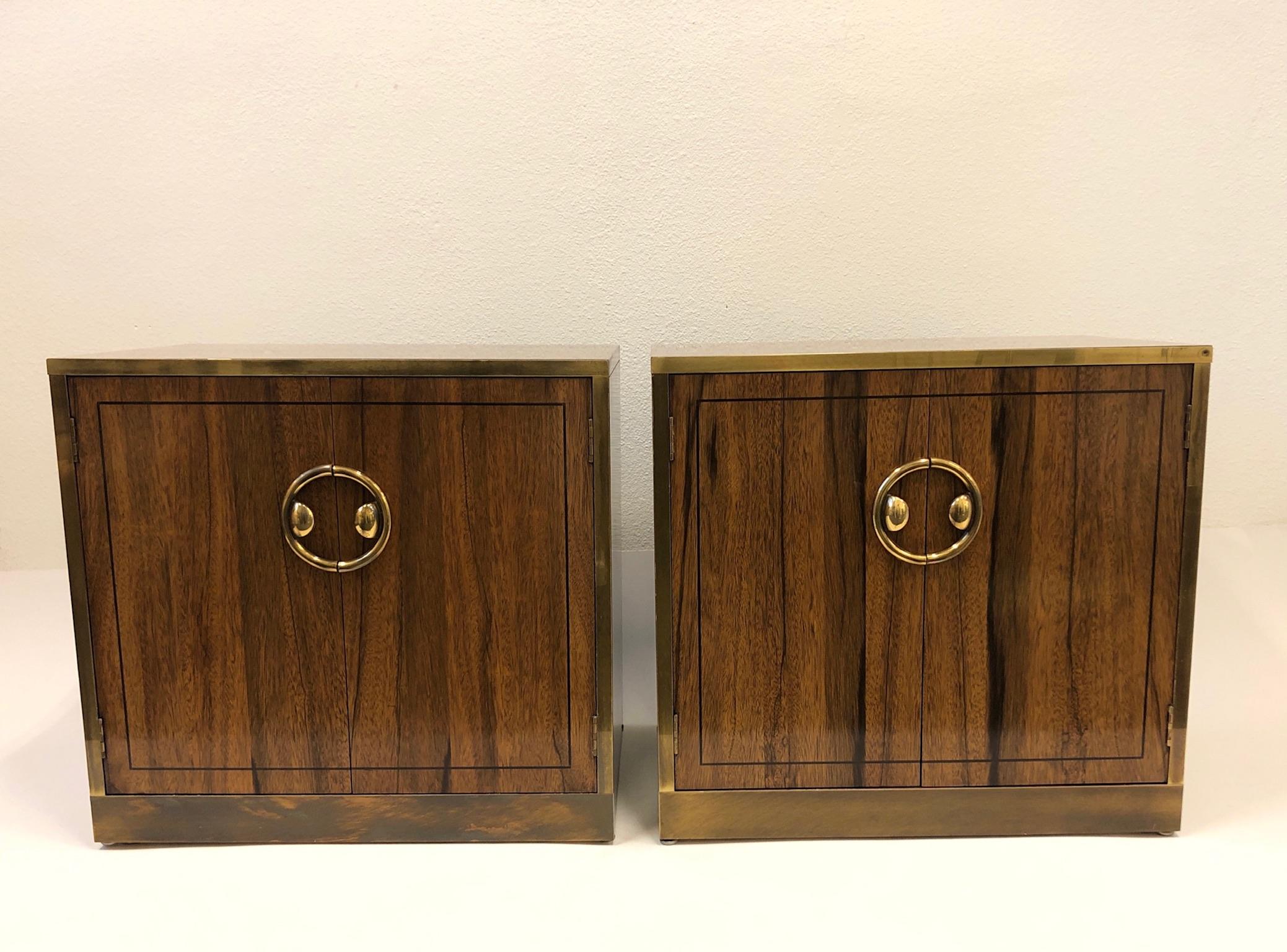 A beautiful pair of nightstands designed by Mastercraft in the 1970s. The nightstands are constructed of dark walnut wood with a zebra wood veneer and aged brass on the outside. Each nightstand have one shelf. The nightstands shows minor age, but no