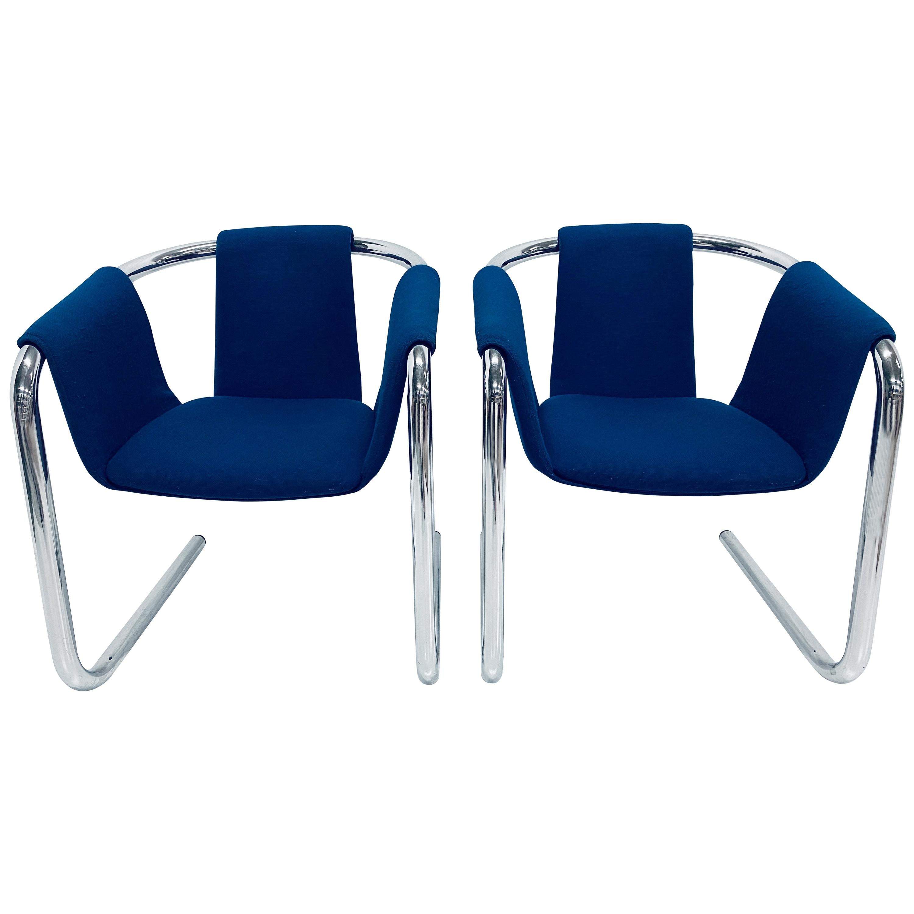 Pair of sling armchairs by Duncan Burke and Gunter Eberle with tubular chrome cantilevered frame and blue wool fabric cushioned seat. The seat is suspended from the tubular frame. Manufactured by Vecta.

The fabric is in original condition with no