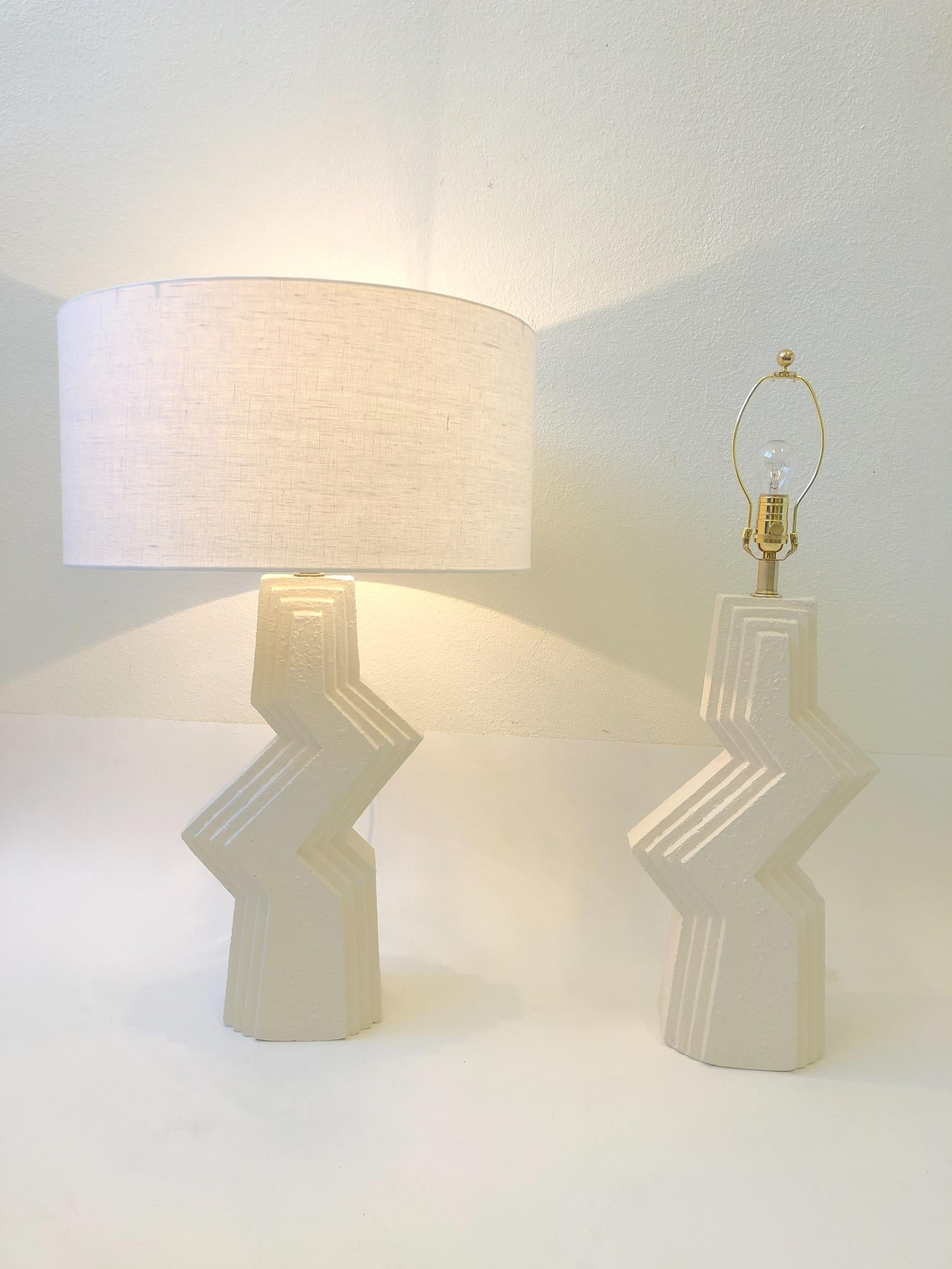 A beautiful pair of Zig Zag, off white plaster and brass hardware table lamps from the 1980s. The lamps have been newly rewired and new vanilla linen shades.
Overall dimensions with shade: 31” high 20” diameter.
 