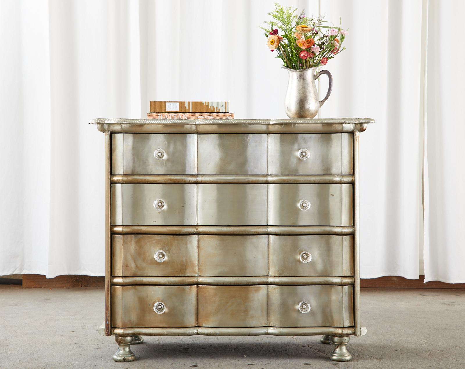 Dazzling pair of commodes, chests, or dressers featuring a hand-wrapped polished zinc sheet metal veneer. The zinc metal is secured with hundreds of hand-hammered tiny nails in a painstaking laborious process. The chests are crafted from a wood case