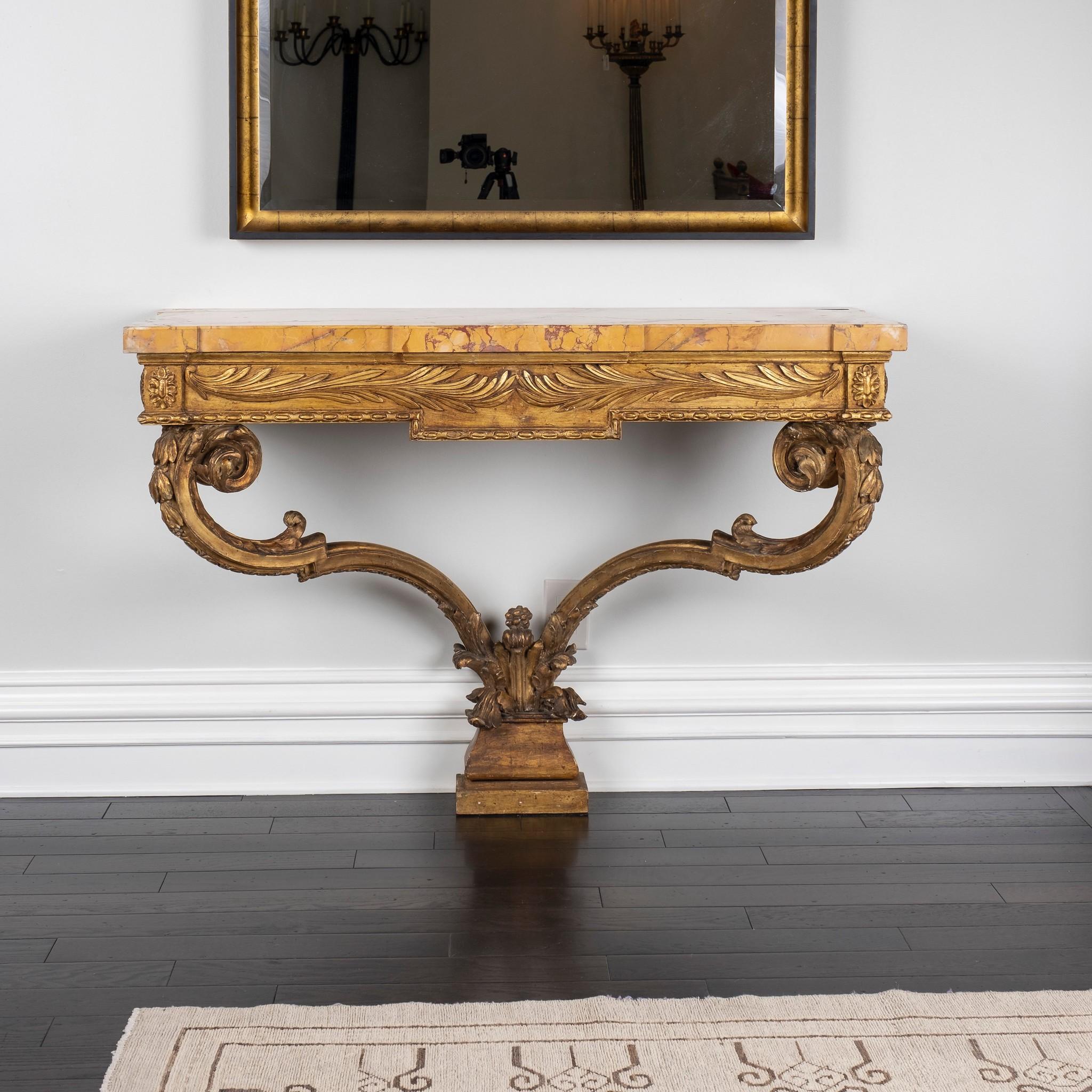 Pair of early 19th century French Louis XVI style giltwood console tables with beautiful Siena marble tops. These larger consoles have classical detailing to include scrolling acanthus, floral, fauna, egg and dart carving.