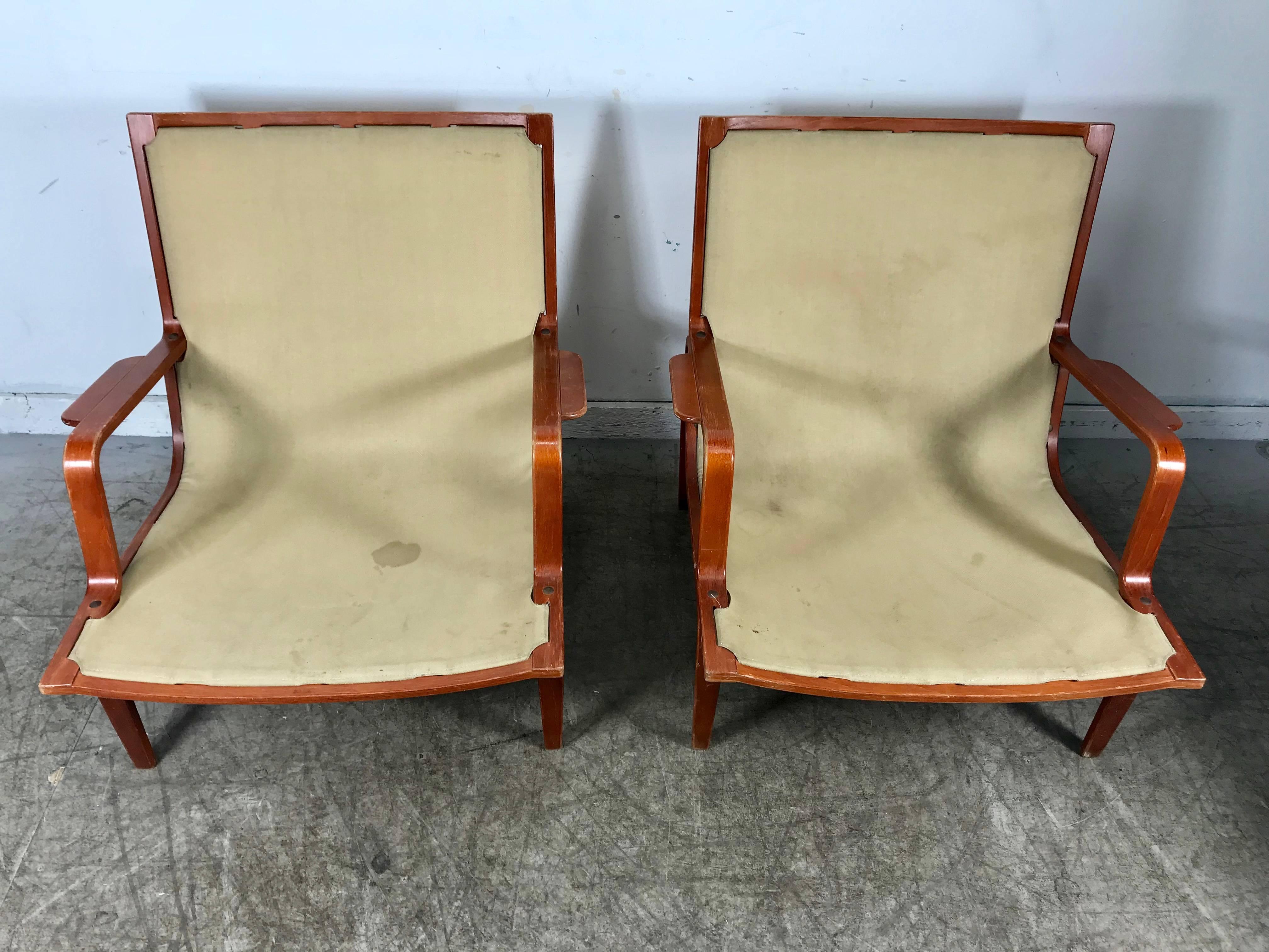 Pair of Bruno Mathsson Ingrid chairs Made by DUX, retain original finish and canvas slings, no cushions or armrests. Classic modernist design.