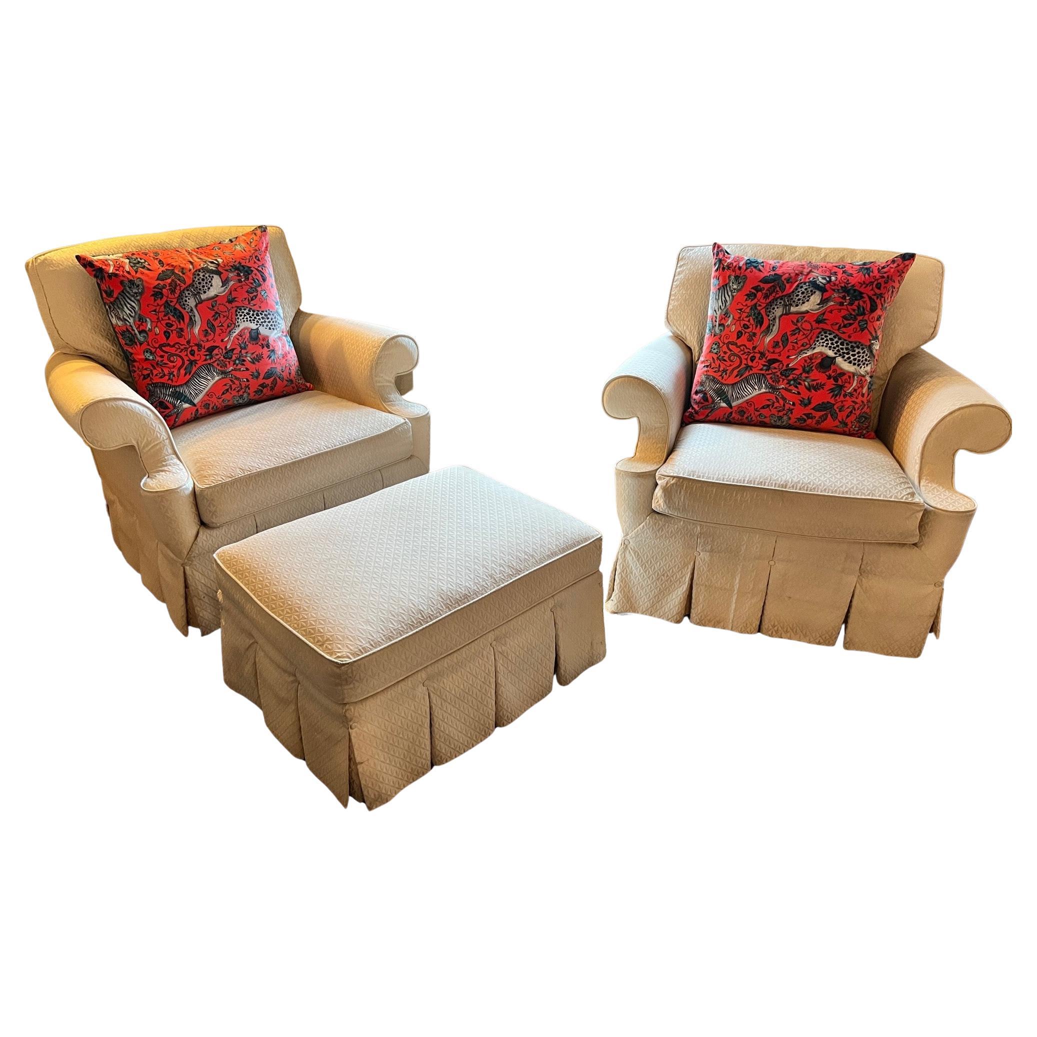 Late 20th C. Hickory chair off white matelassé covered swivel club chairs with a matching ottoman. The set is covered in Sovereign Upholstery by Hickory Chair with a welt trim and kick pleat skirts accented by covered buttons. The chairs have a