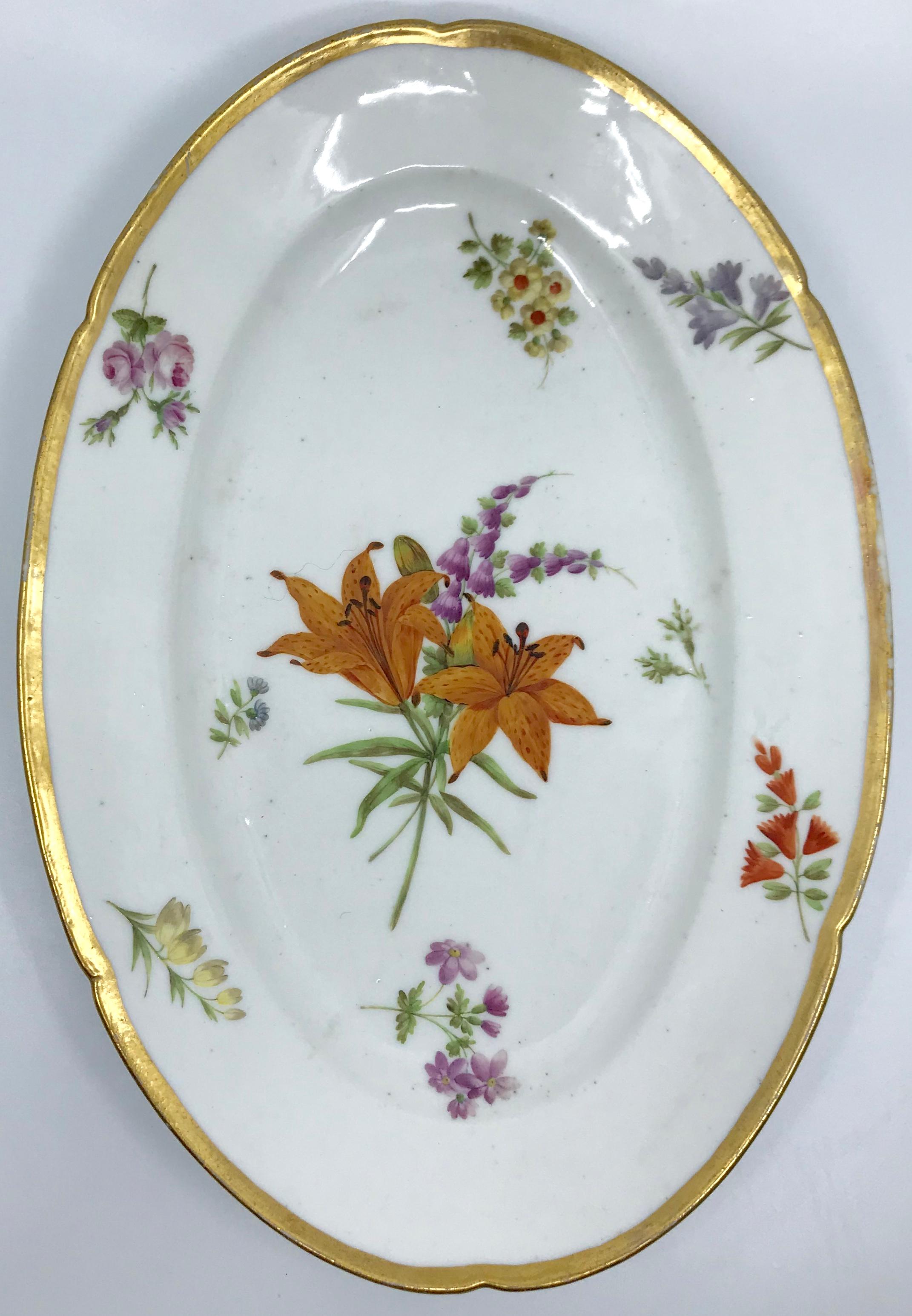 Pair of old Paris gilt porcelain floral platters pair lozenge shaped gilt rimmed serving platters with lobed gilt banding of different flower sprigs centering central lozenge with lilies and old roses in beautiful condition with minor wear to some