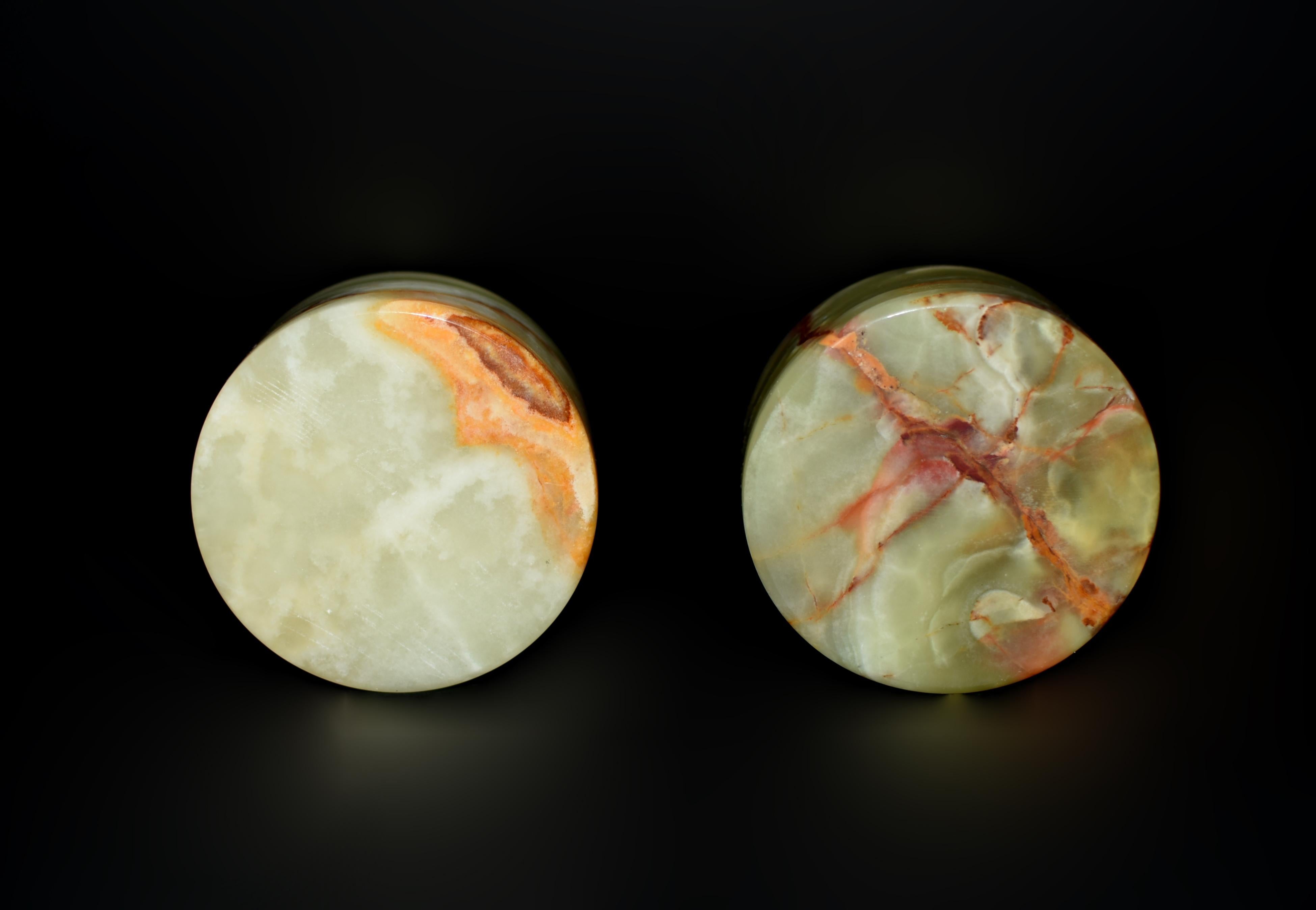 A pair of beautiful natural onyx containers. In cylindrical forms, finely crafted from refined Pakistani onyx prized for their distinct veining and crystalline texture. One box displays a blend of earthy tones, with swirls of butterscotch, amber,