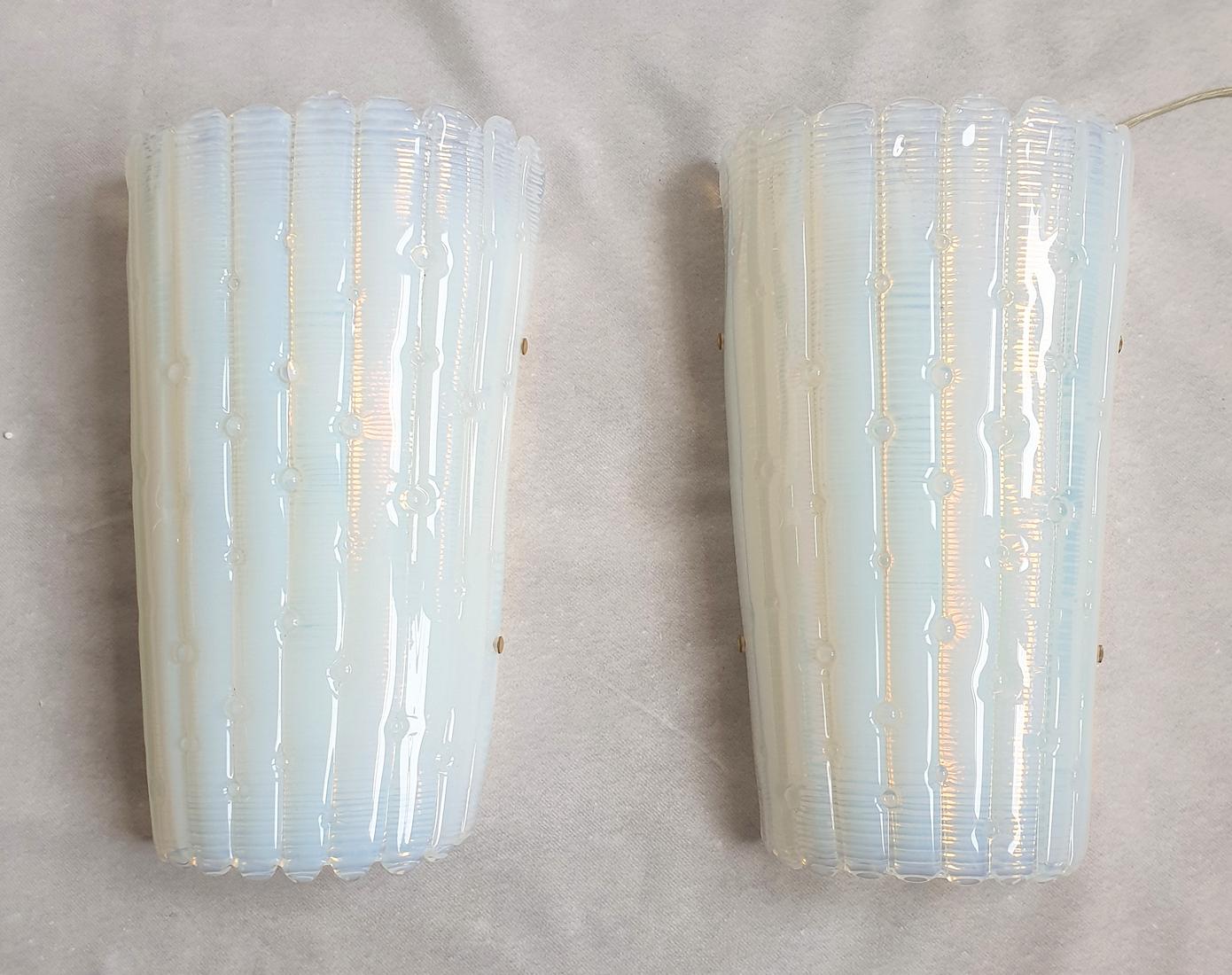 Vintage opaline Murano glass wall sconces, attributed to AV Mazzega, Italy 1970s.
The Mid-Century Modern sconces are made of a single opaline Murano glass, with a nice pattern; the particularity of opaline is the changing colors through the light: