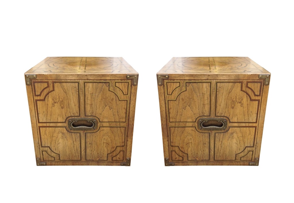 Pair of decorative side tables with a very nice decorative geometric design on all sides.
The tables are designed in the campaign style with metal pegs on the corners and a brass handle.
The wheels on the bottom allow them to slide very easily and