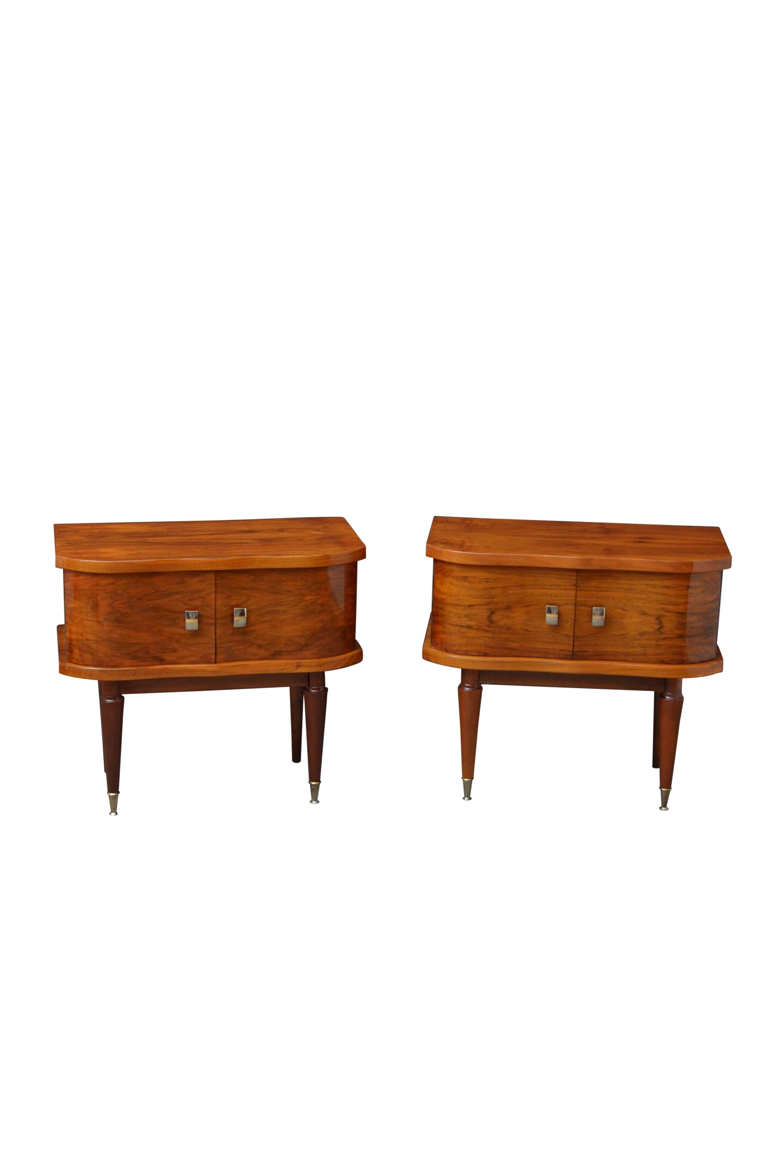 K0549 Superb pair of low bedside cabinets, each having shaped top with well figured grains, pair of serpentine doors fitted with original metal handles, standing on turned, tapered legs terminating in metal cups. This antique pair of bedside