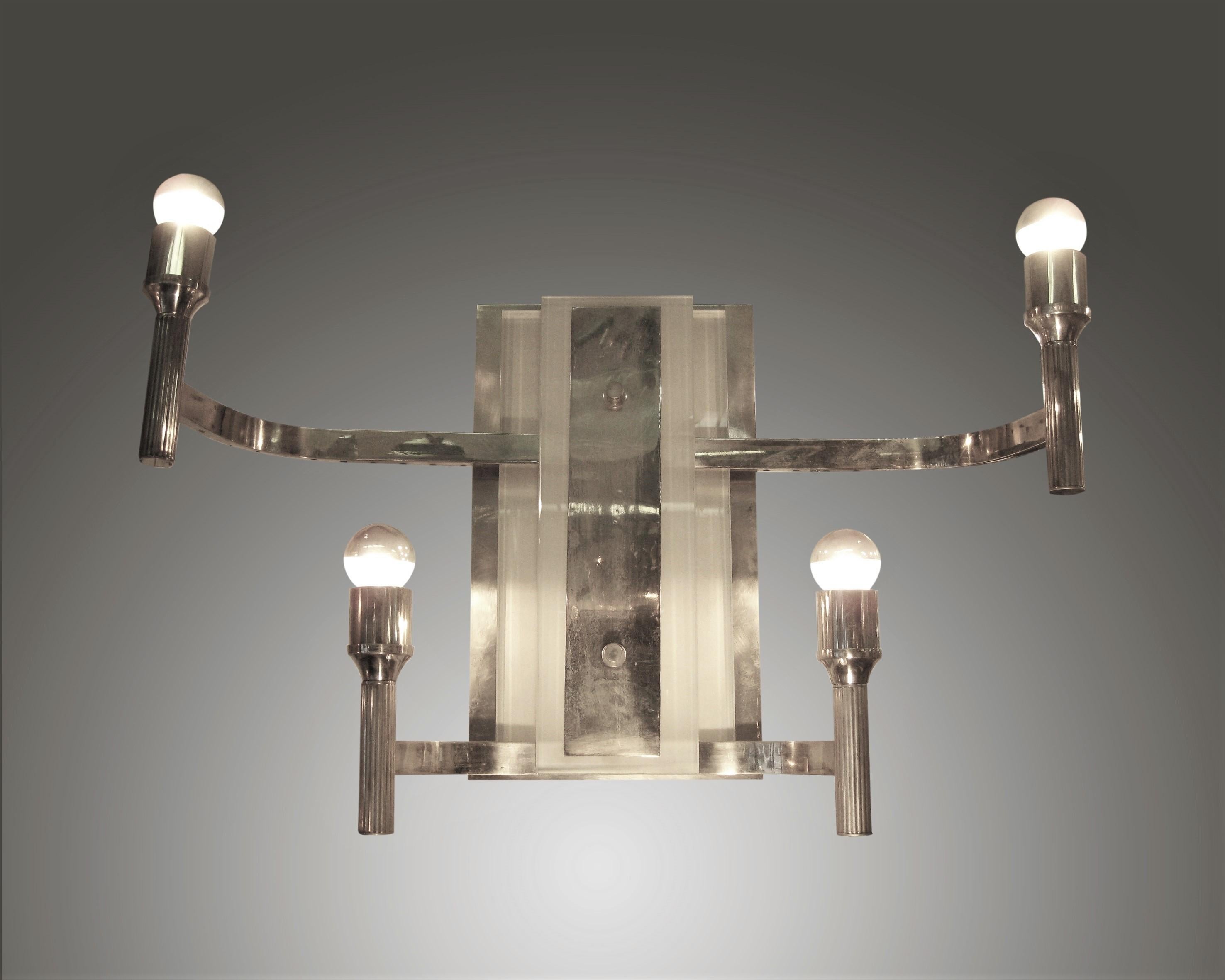 Pair or four French modernist sconces with four arms extending from a stepped frosted glass back plate ending in a vertical fluted torch arm. The half inch thick solid slabs of frosted glass add a three dimensionality to the lustrous back