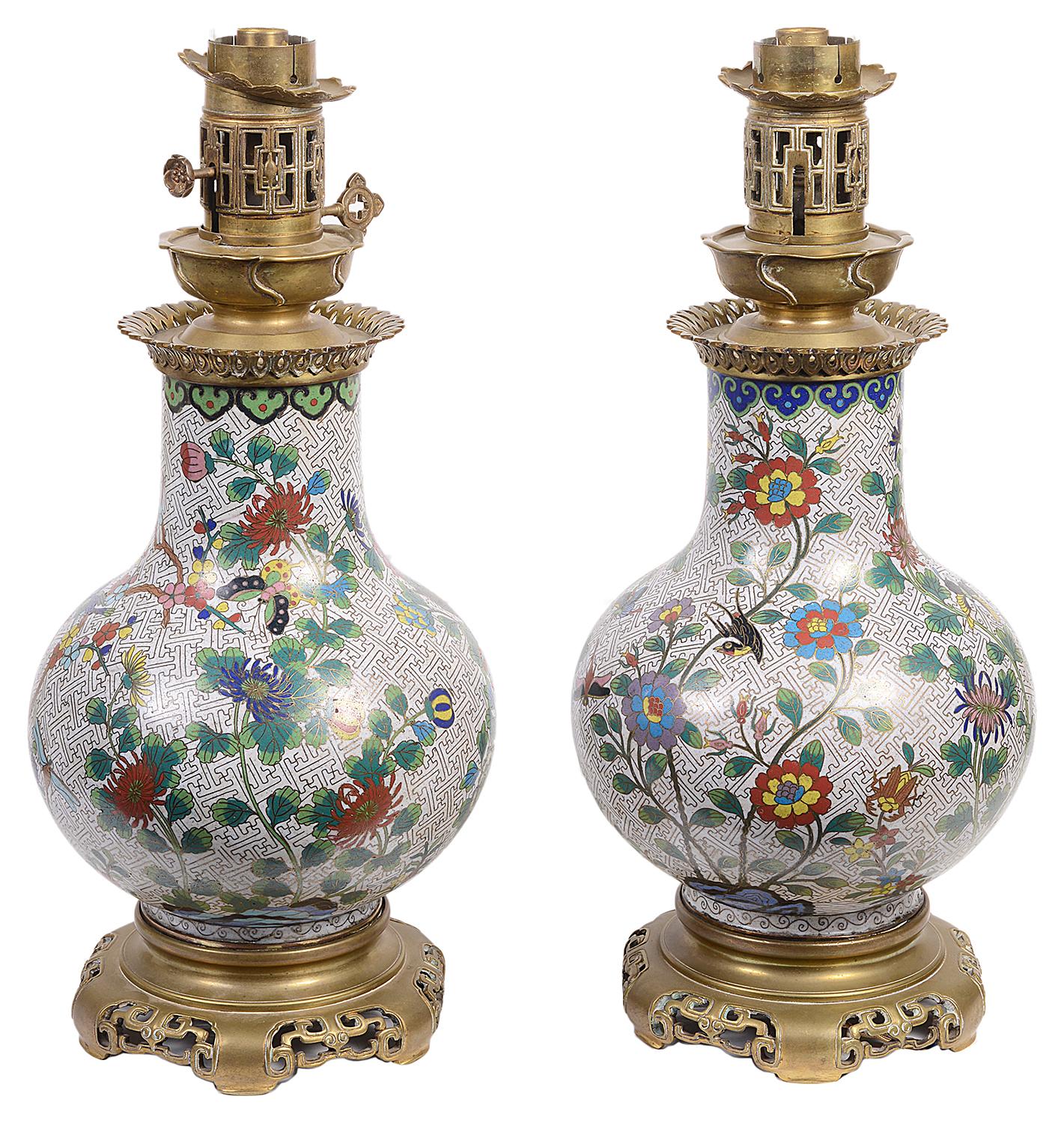 Une paire de vases / lampes en émail cloisonné de style oriental français de bonne qualité, chacun ayant une merveilleuse décoration florale avec des oiseaux, des papillons et des libellules, montés avec des dessus en bronze doré et des supports de
