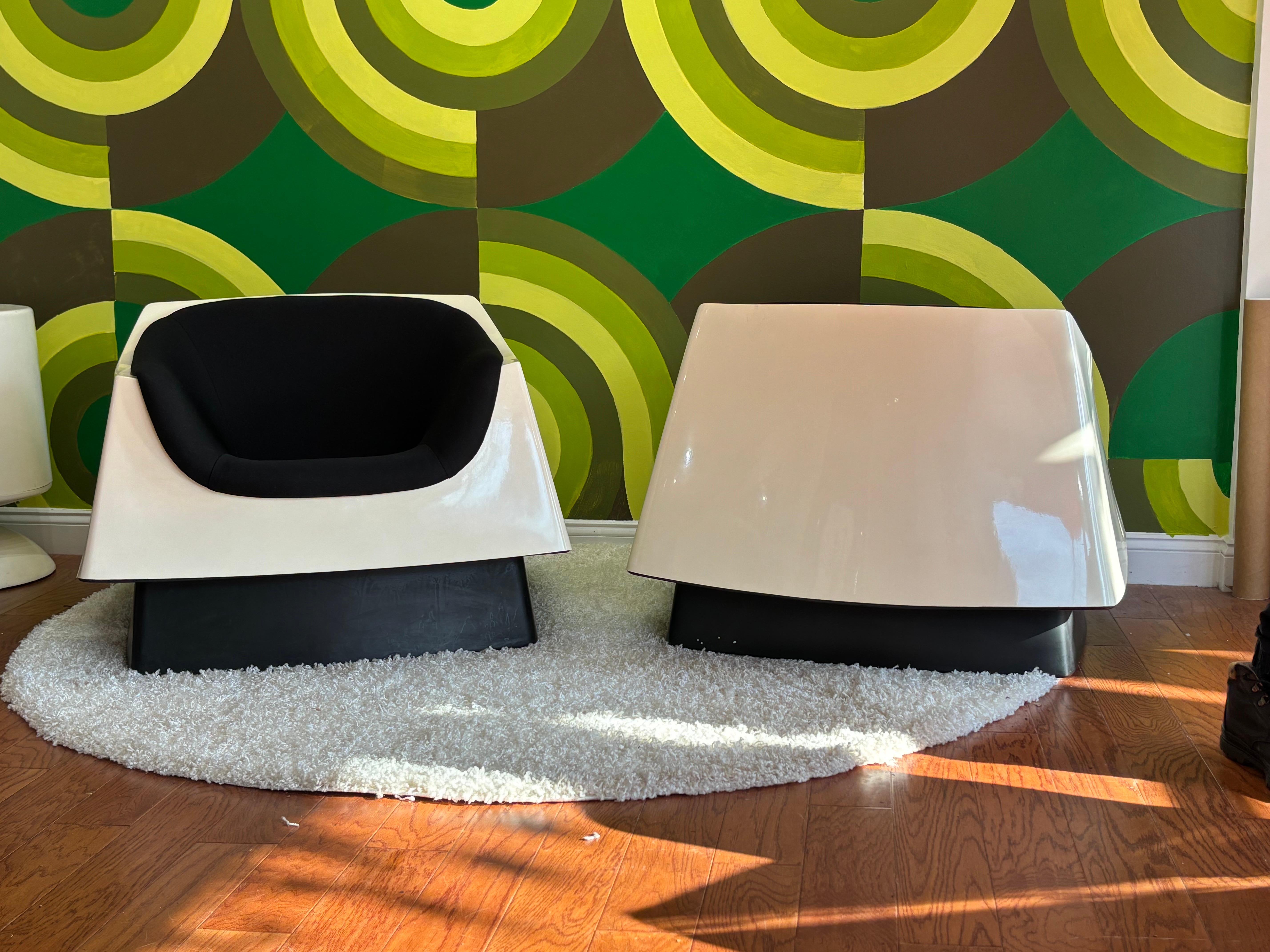 A Pair of fully upholstered space age Vecta chairs in very good original condition.  Refinished in a black upholstery on an original cream white shell. These chairs are often found in less than pristine condition  this set minus a few very small