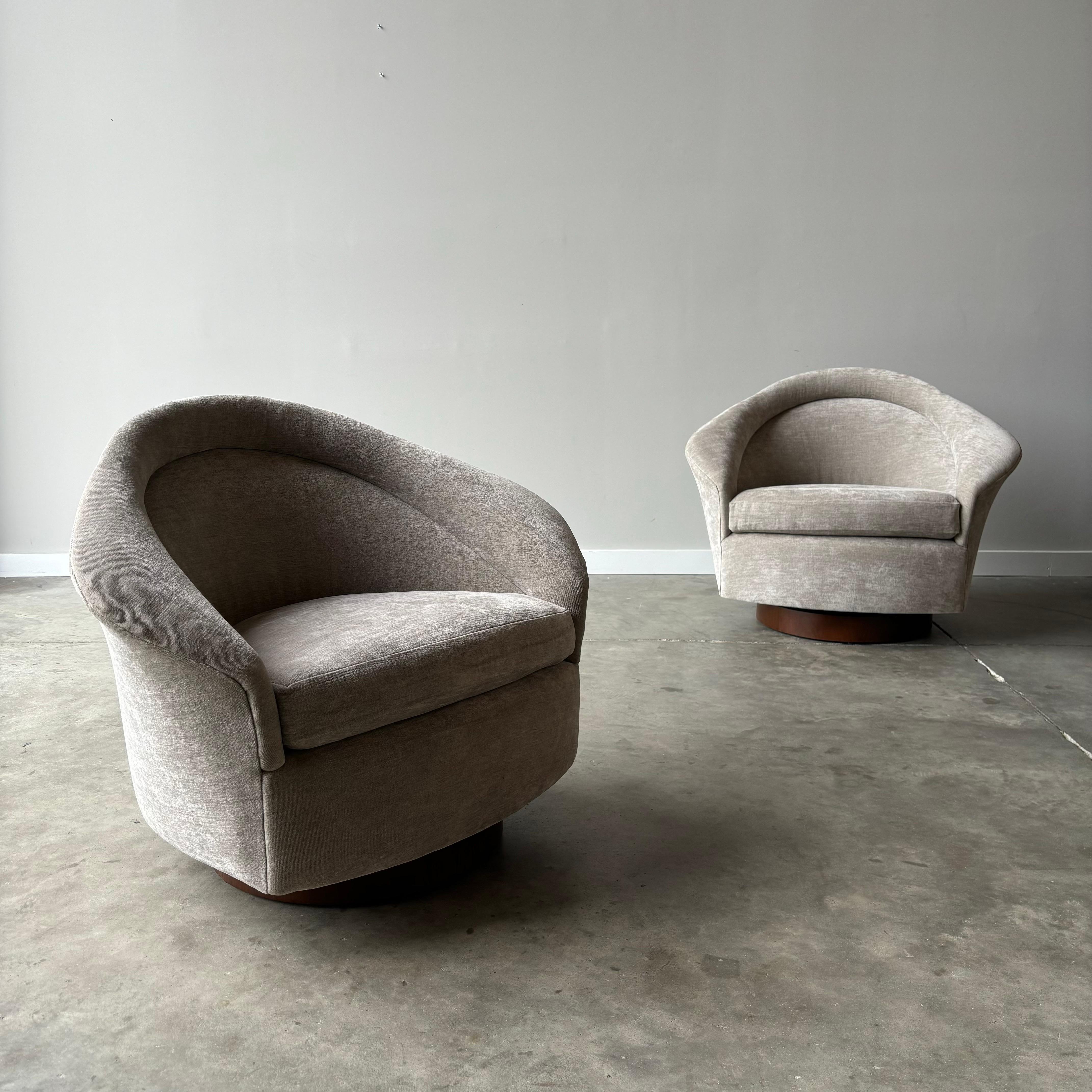VIntage 1970s sculptural lounge chairs by Adrain Pearsall newly upholstered in taupe velvet sitting on the walnut plinth bases.  Extremely comfortable and widely functional with the swivel/rocking mechanism in a small footprint.  A wonderful design