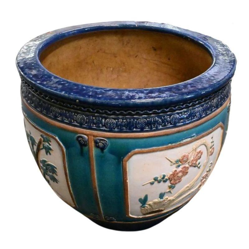 A pair of vintage oversize painted ceramic round planters with a chinoiserie floral motif. The large jardinieres are glazed with a lapis blue at the top and the design is divided into panels with a backdrop of sea green, bordered in brown. Each