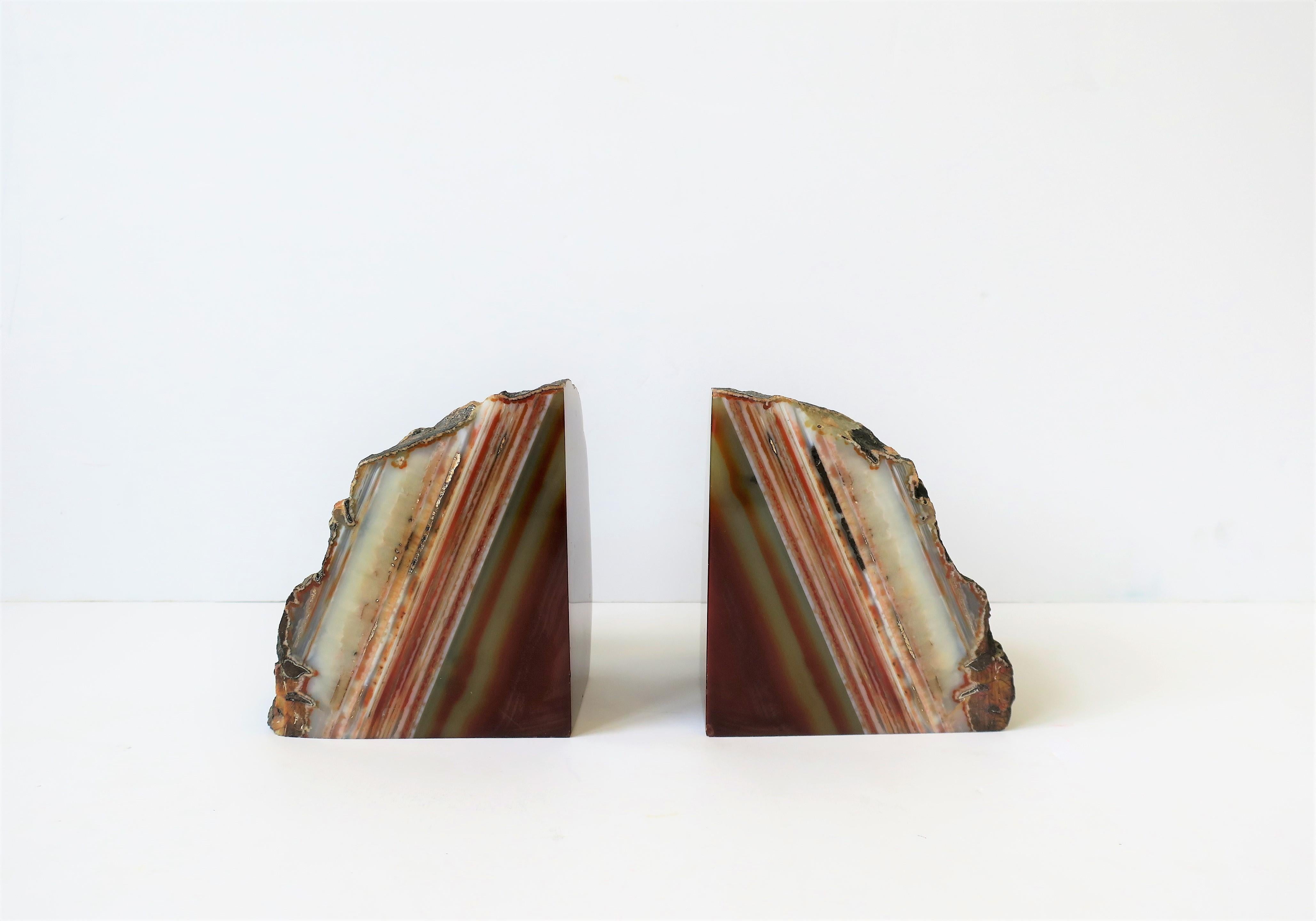A substantial and beautiful pair of red burgundy onyx marble bookends or decorative objects. Colors include shades of white, red burgundy, and a touch of gold. Dimensions: 3.75