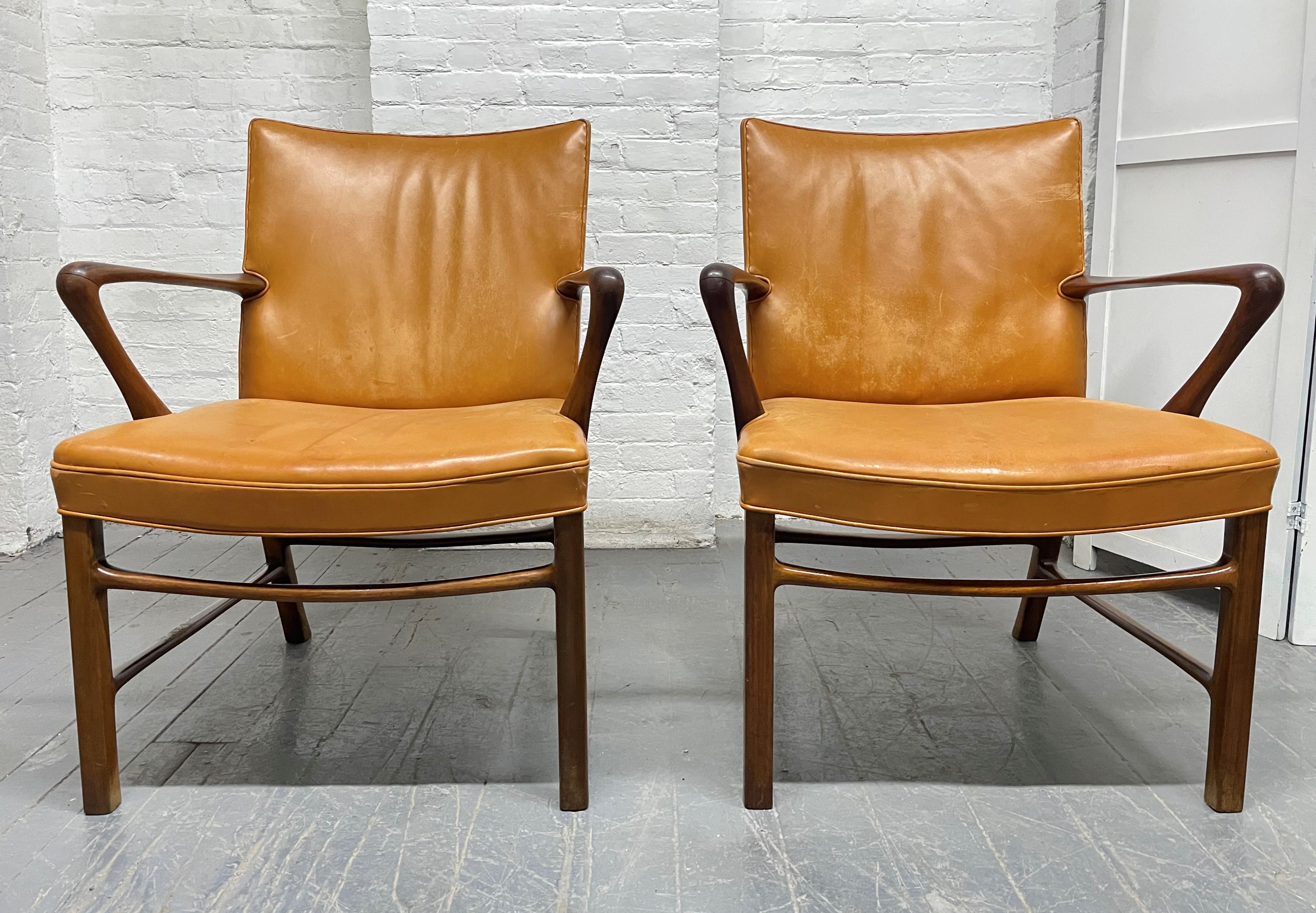 Pair of Palle Suenson armchairs for Jacob Kjaer. The frames of the chairs are walnut with the original Niger leather. These chairs have nice lines and are constructed well with curved arms. The chairs are hard to find in its original condition.