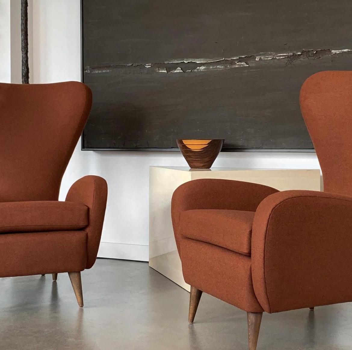 Pair of Italian sculptural wingback lounge chairs by Paolo Buffa, circa 1950s. These chairs have been newly upholstered in a felted wool fabric in a sophisticated slightly feathered rust color. A fabric swatch is available upon request. These high