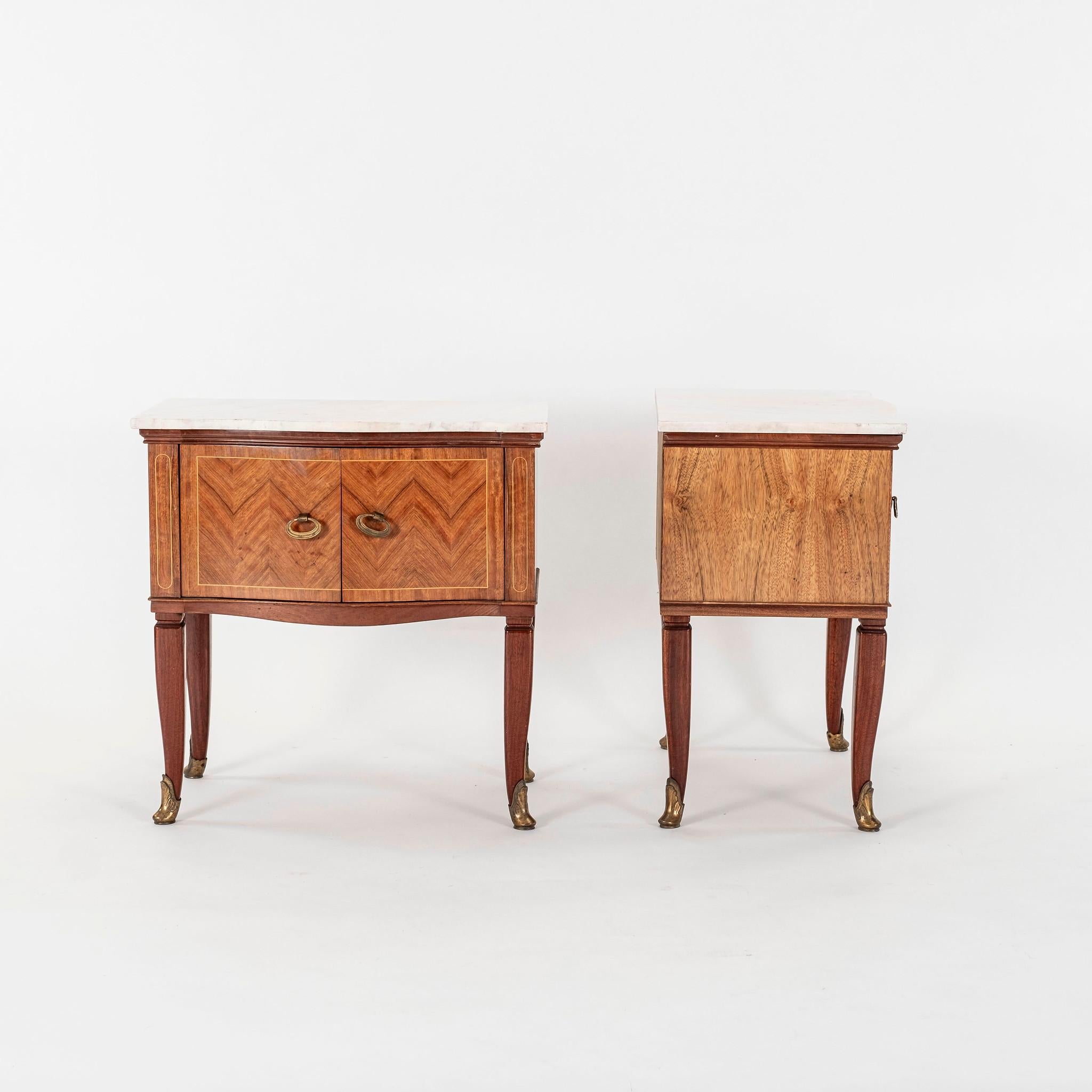 Pair of Italian mid century Paolo Buffa style nightstands. Two door chevron marquetry cabinets with bronze sabots and marble tops.