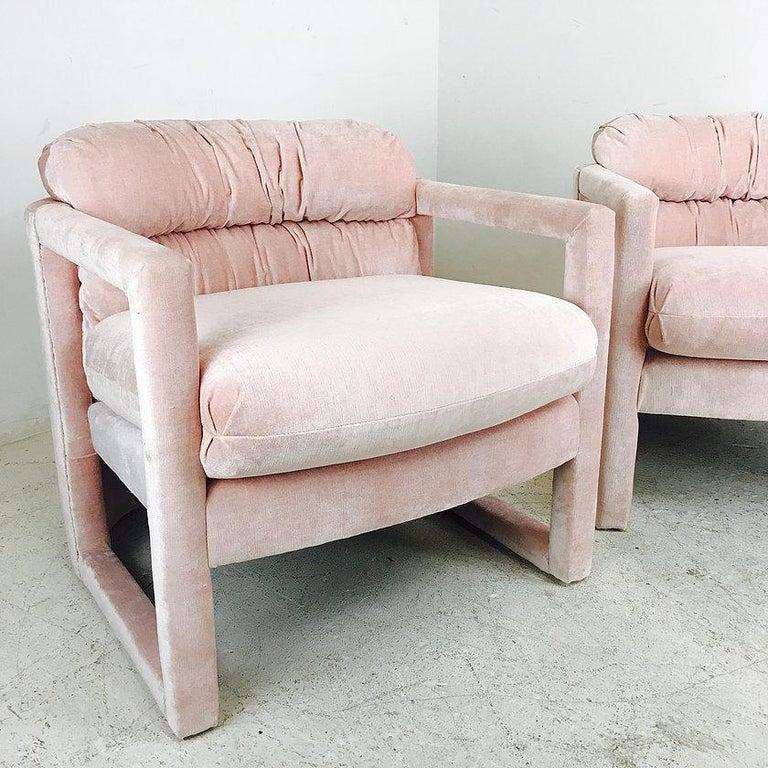 Sleek pair of Mid-Century Modern armchairs by Drexel. This comfortable set has a lot of style featuring upholstered frames with cutout arms and rounded barrel backs. Professionally upholstered in a soft pink velvet fabric. A Classic pair that can