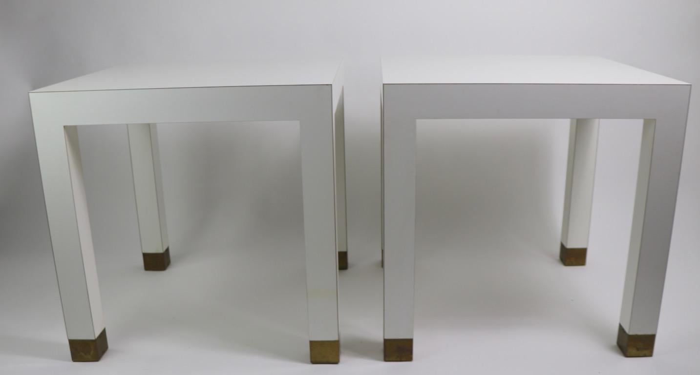 Probably the best quality formica tables we have seen, with muscular form, excellent construction, design, and condition. Each table has decorative brass feet (2.75 inch H) to contrast the white formica legs and top. Originally designed for use as