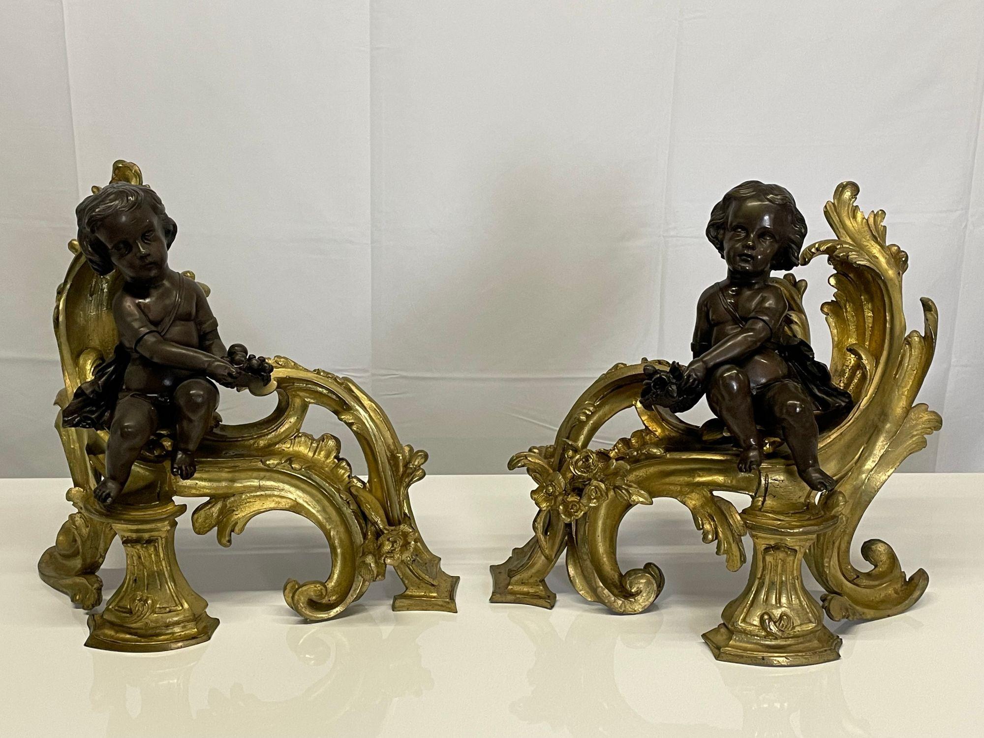 Pair of Louis XV Style Patinated and Gilt Bronze Cherub Fireplace Andirons or Chenets
 
 A pair of stunning opposing Cherub Louis XV Style Gilt and Patinated Bronze Figural Chenets. Each having a 9 inch Cherub in Greek robe bearing fruit. The pair