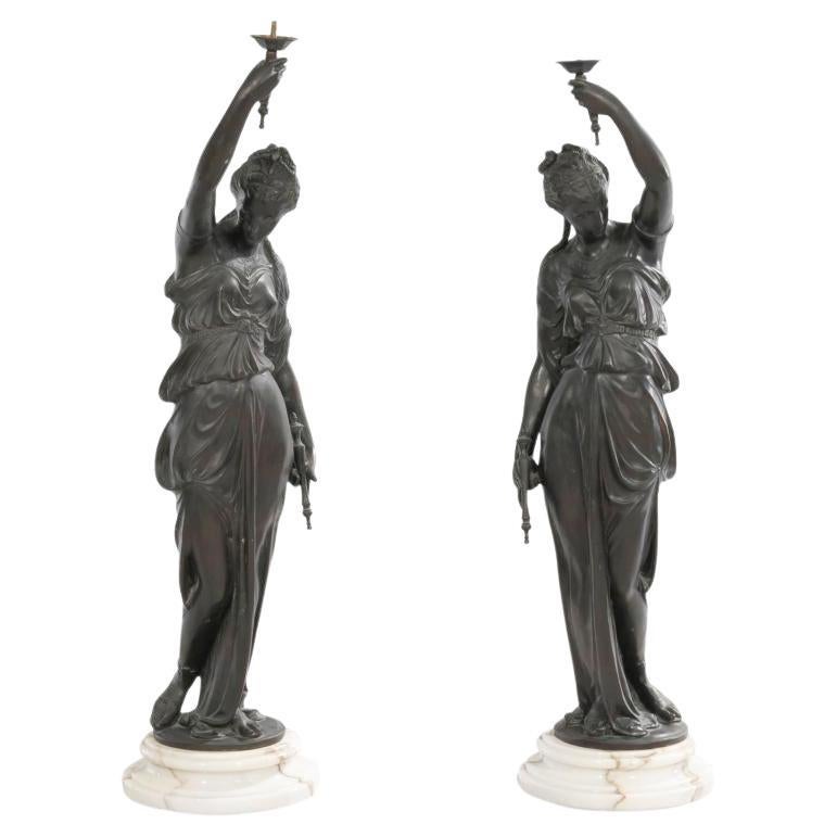 Coppia di figure femminili in bronzo neoclassico patinato, concepite come torciere