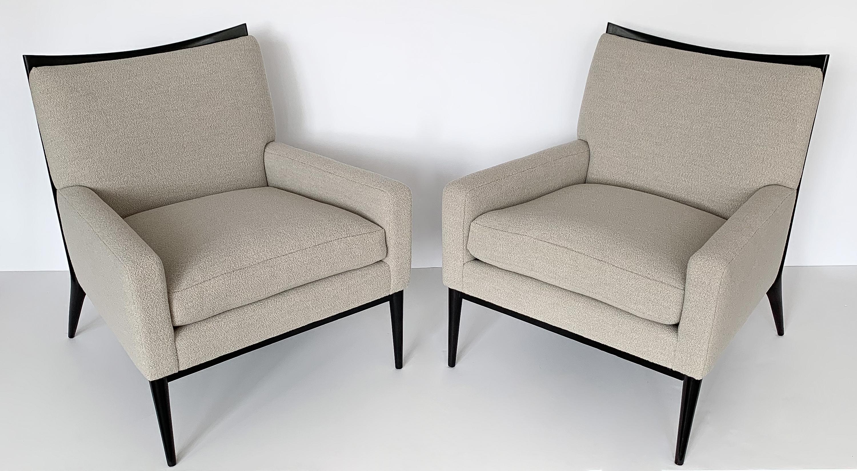 Pair of lounge chairs by Paul McCobb for Directional Furniture, circa 1950s. Model 1322. Original black ebonized wood frames with tapered legs and striking curved back. Newly upholstered in a sophisticated pale stone gray bouclé by Holland and