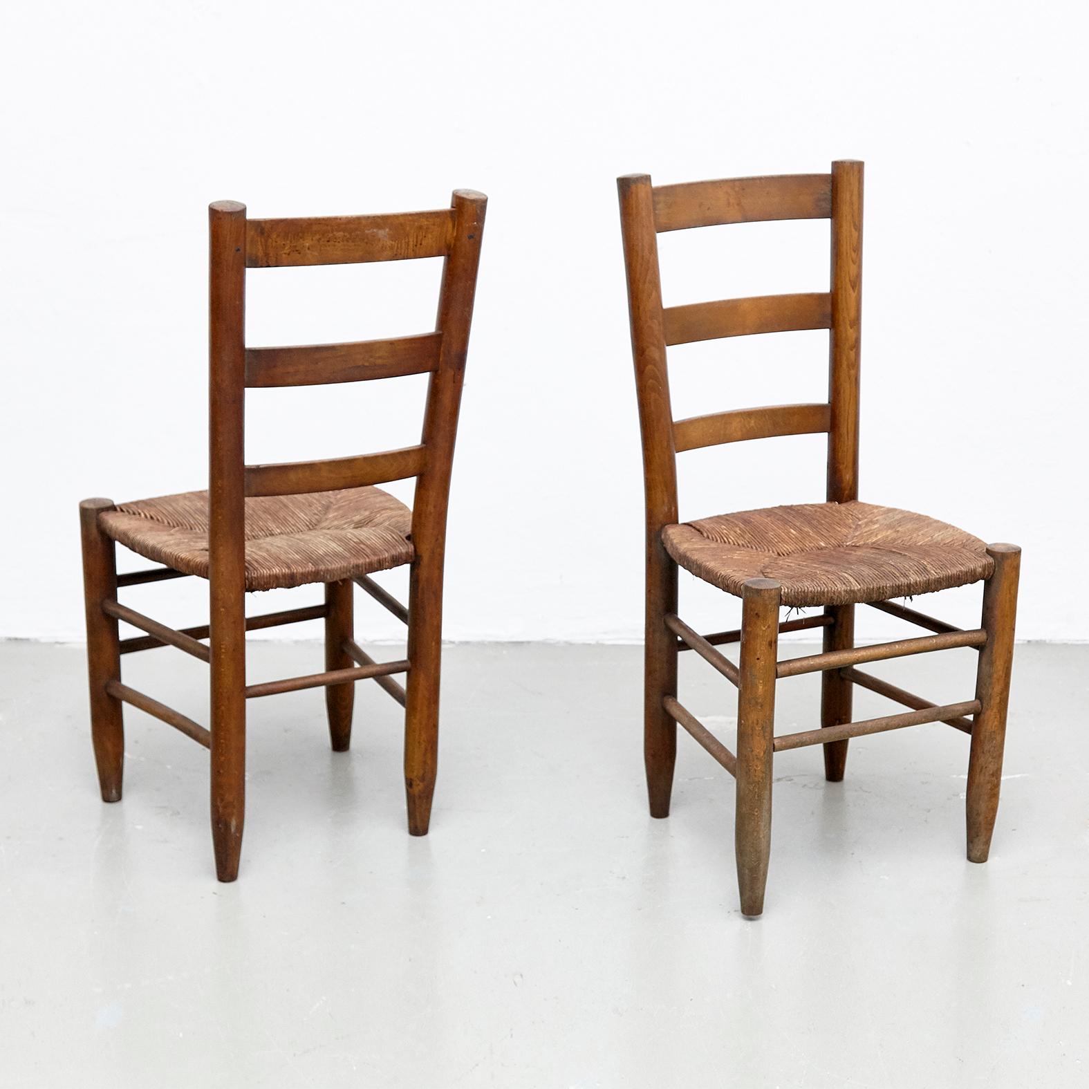 Pair of dining chairs, model Meribel, designed by Charlotte Perriand, circa 1950.

Solid wood base and legs, and rush seat.

In good original condition, with minor wear consistent with age and use, preserving a beautiful patina. The seats rush