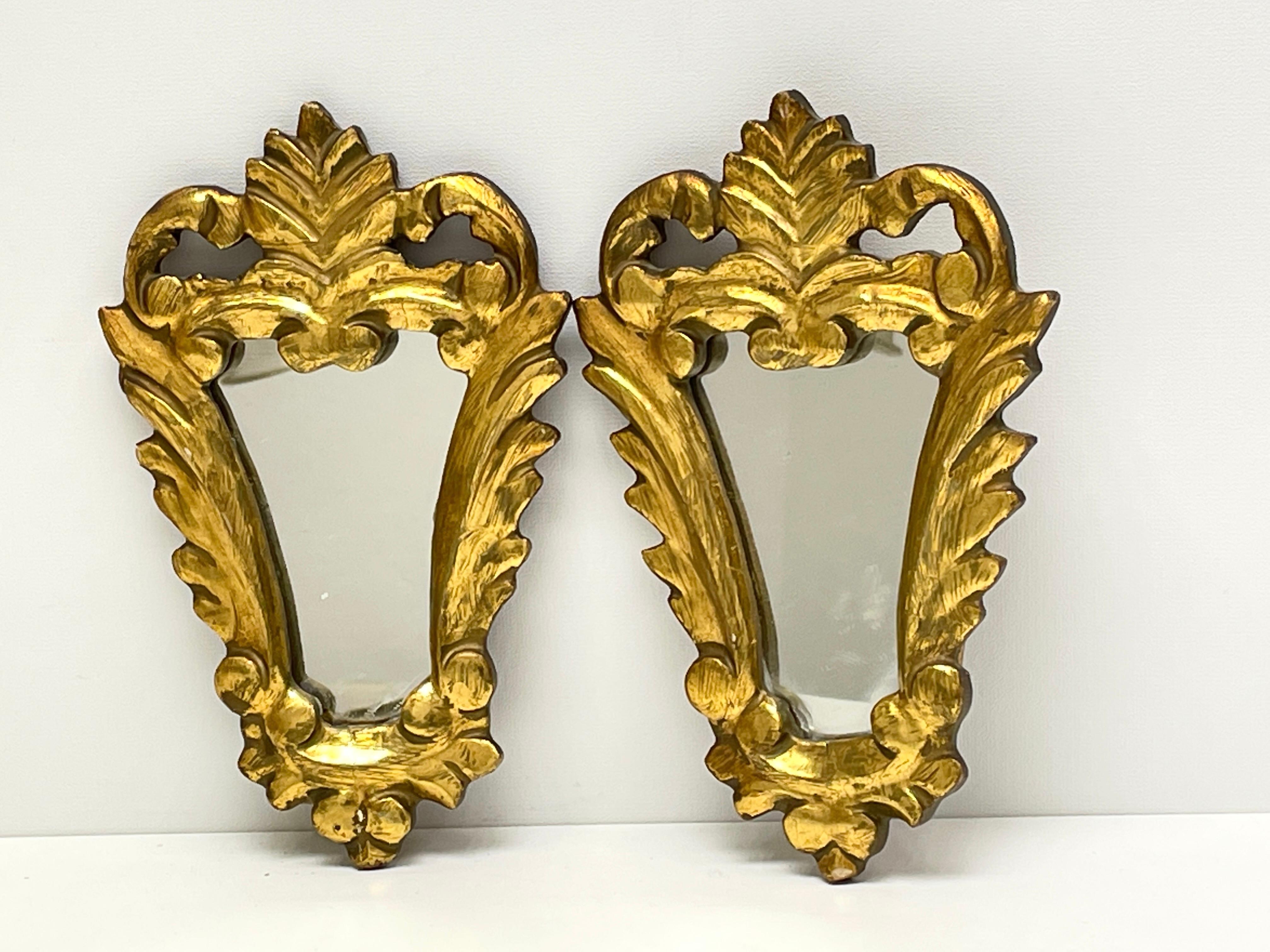 A gorgeous pair of petite toleware mirrors. Made of gilt wood and composition. A nice addition to any room.