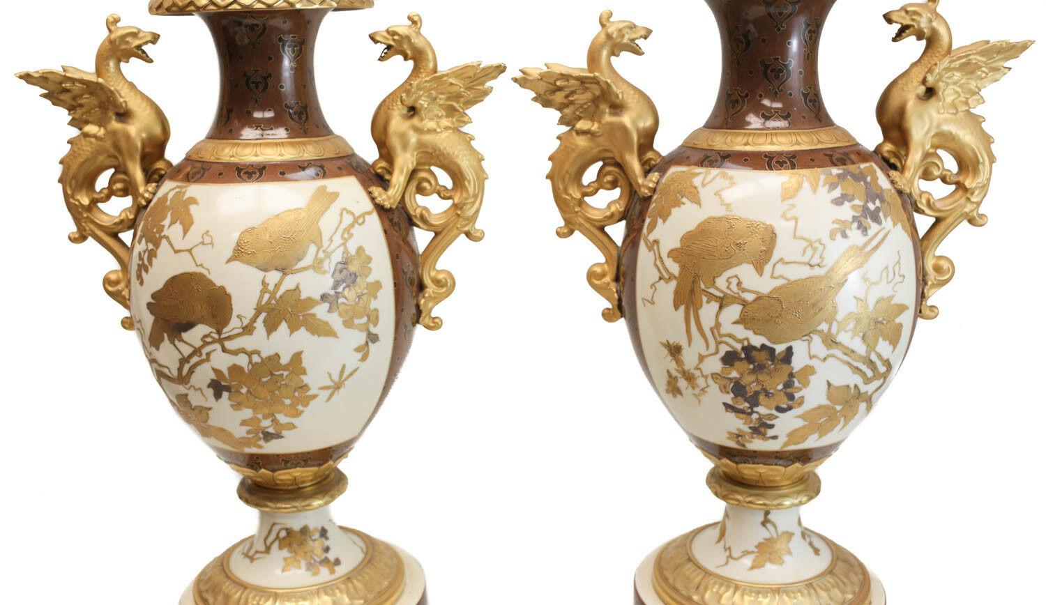 Description: Pair of Pirkenhammer porcelain aesthetic gold encrusted double handled footed vase, circa 1880. The central image of the urns depict gold encrusted birds perched on tree branches with more tree branches to the verso. Gold encrusted