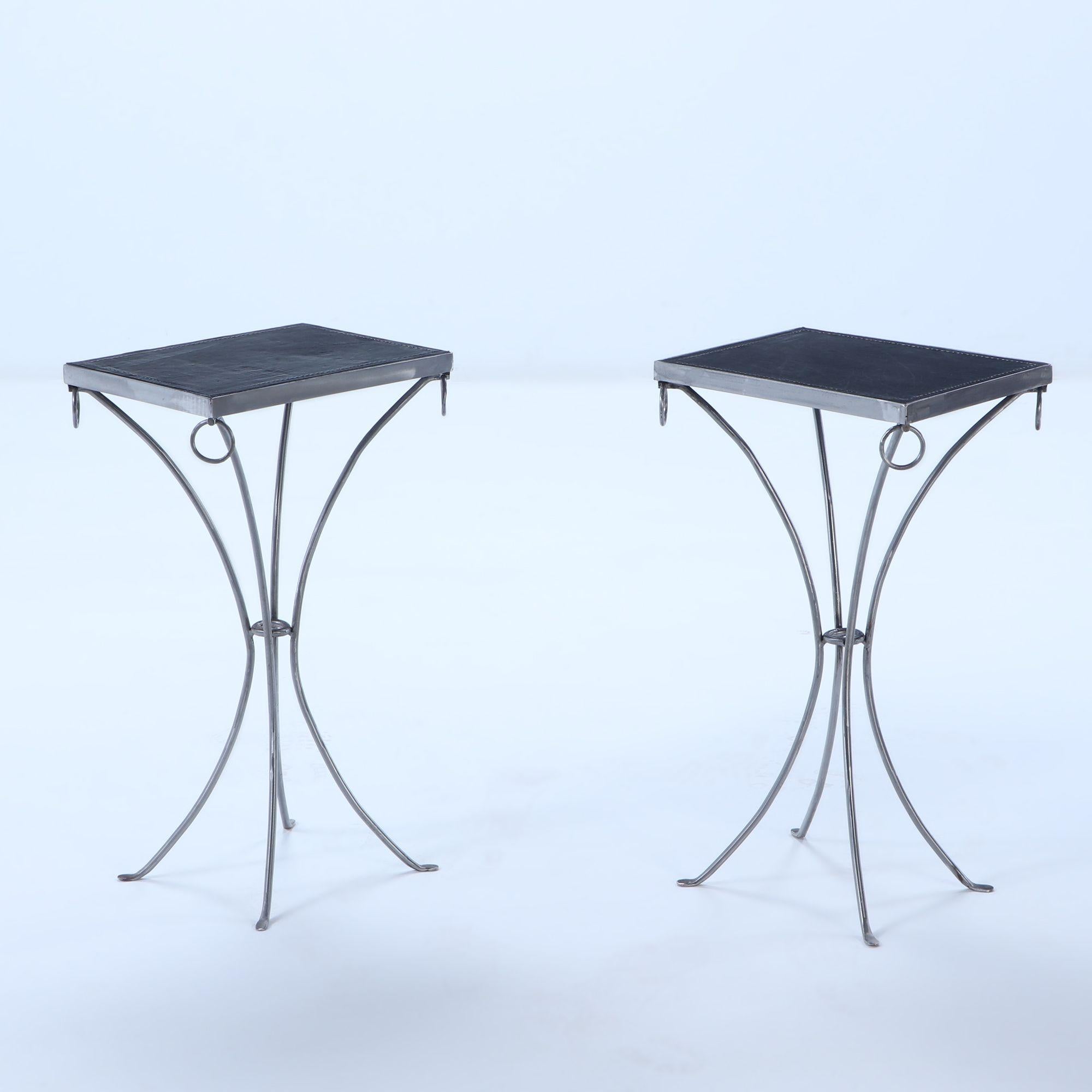 Pair polished iron drinks tables with ring decoration and black distressed leather hand stiched tops so as to look vintage.