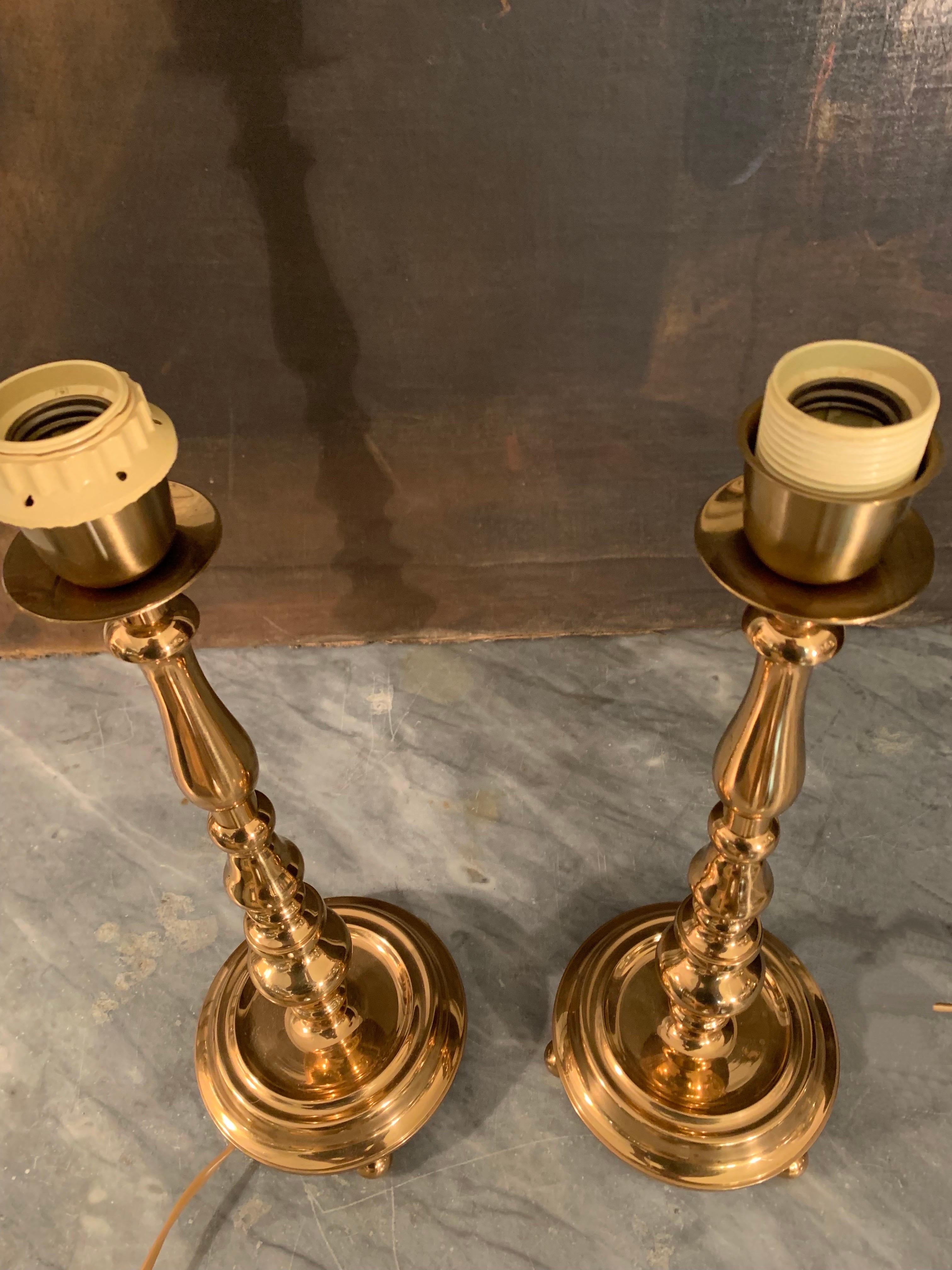 A pair of Swedish lamps, in Renaissance style in solid and polished brass, round base supported by brass balls, are prepared for use in the US, the lampshades are burlap and recently manufactured.