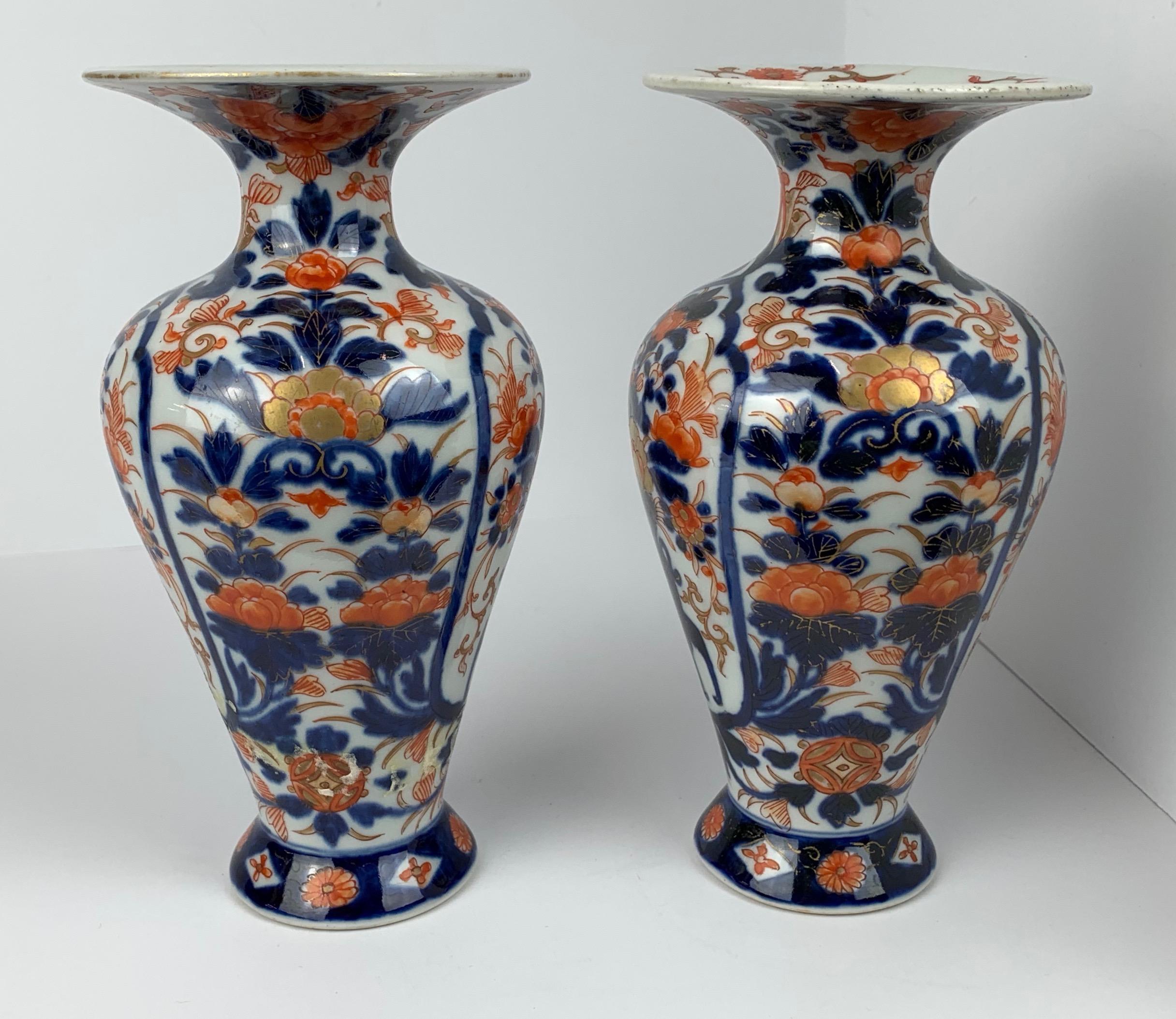Pair porcelain Imari pattern small palace shaped vases. Hand decorated in underglaze blue, iron red and gold. The fluted tops are painted with flowers. The bases are marked in underglaze blue.