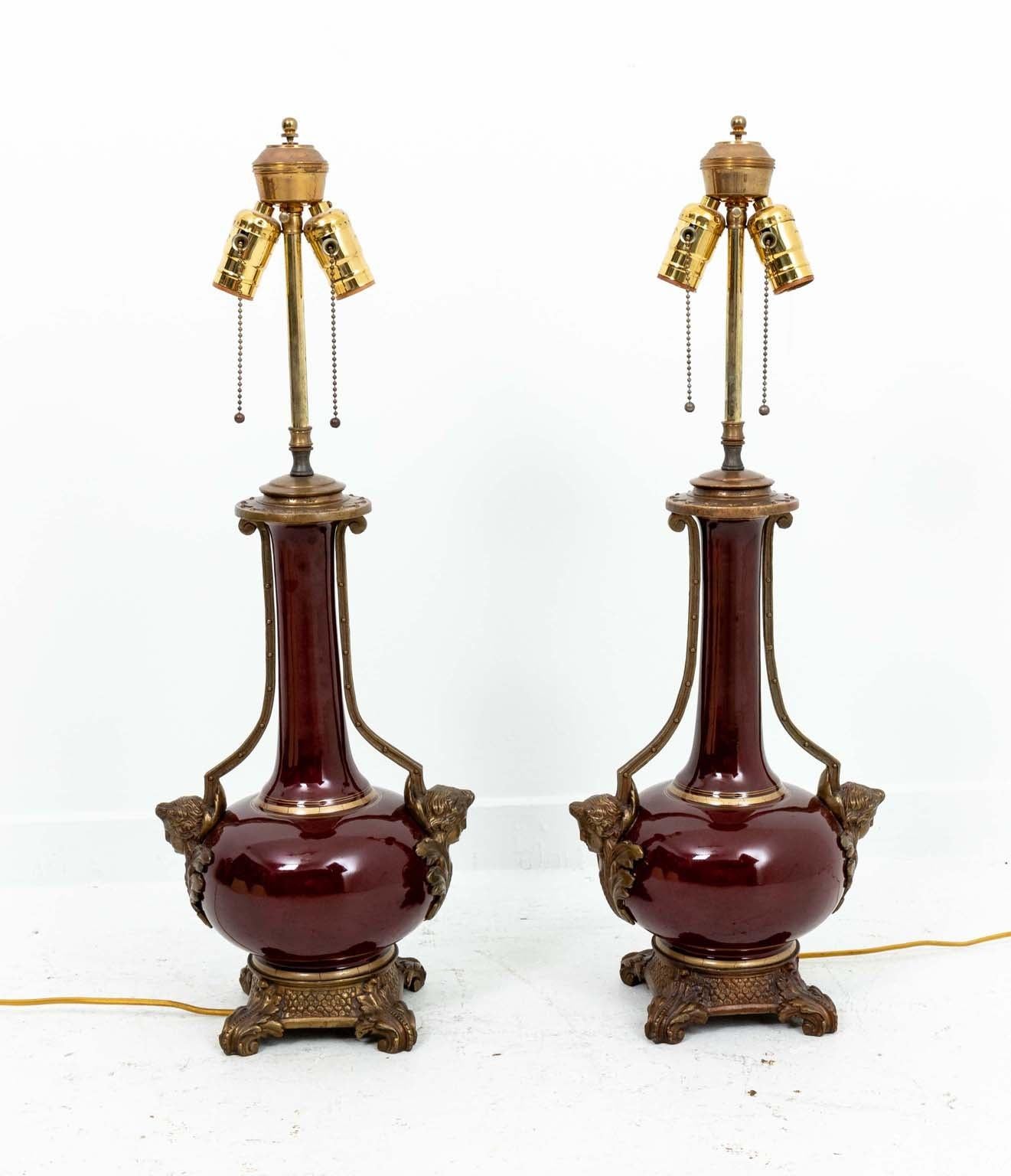 Pair midcentury porcelain oxblood lamps with bronze mounts. Lampshades not included. 
